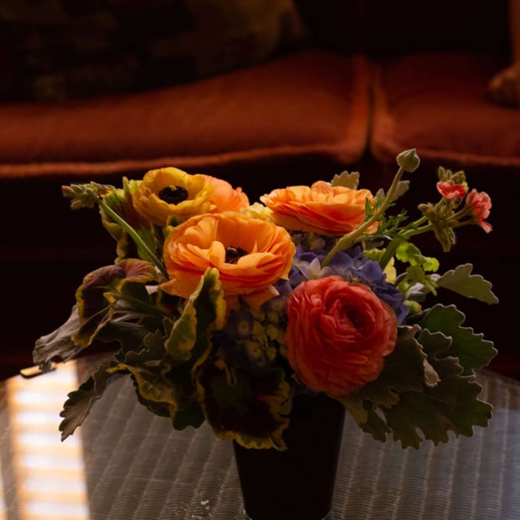 A small arrangement of warmer toned seasonal flowers and soft texture, such