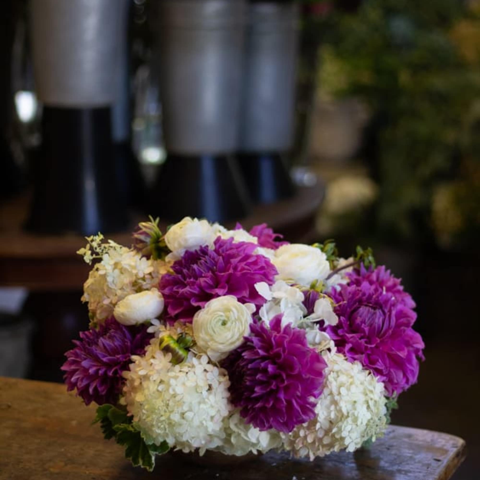 Low bouquet of white and purple flowers on a wooden table