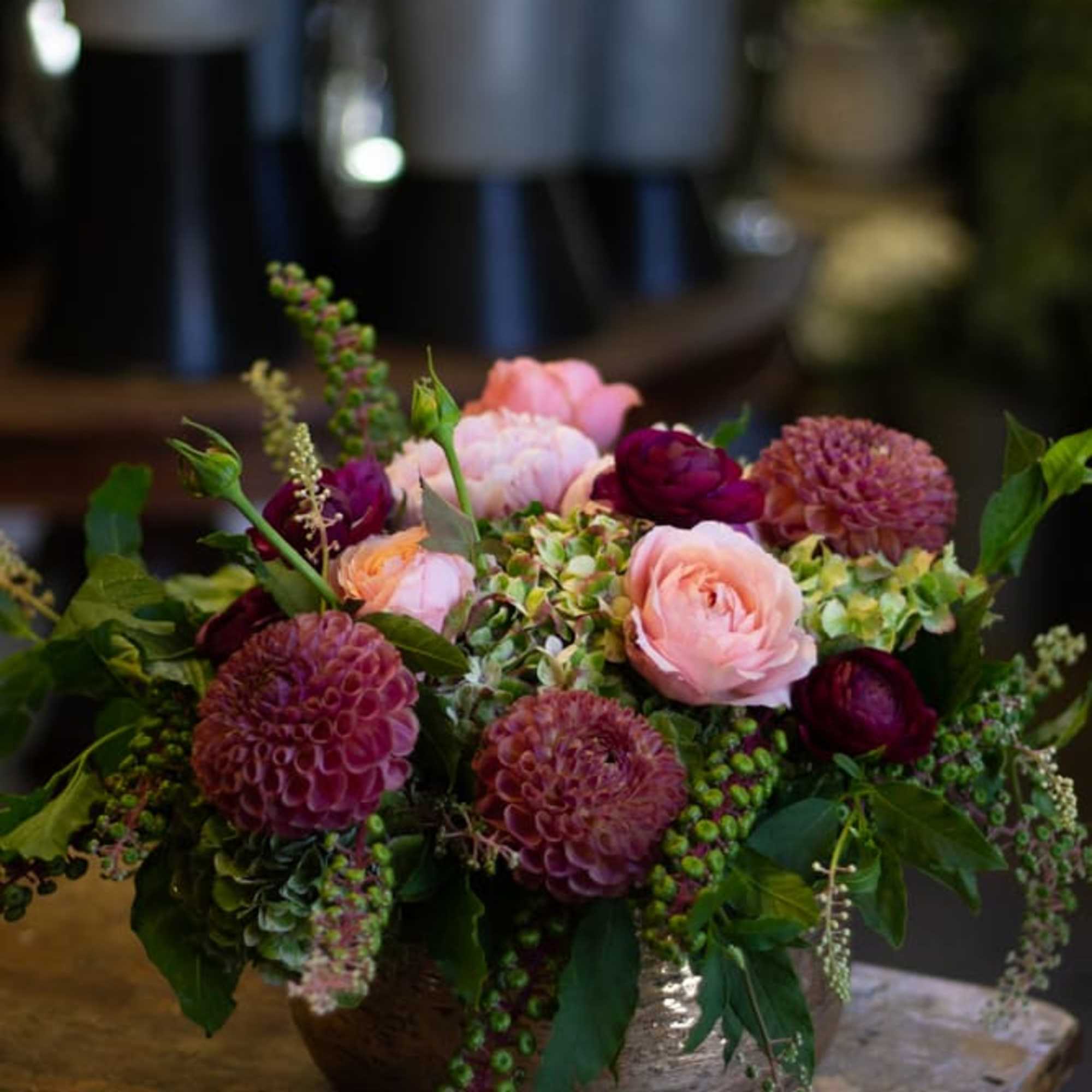 Mixed pink and burgundy flowers arranged in a low bowl