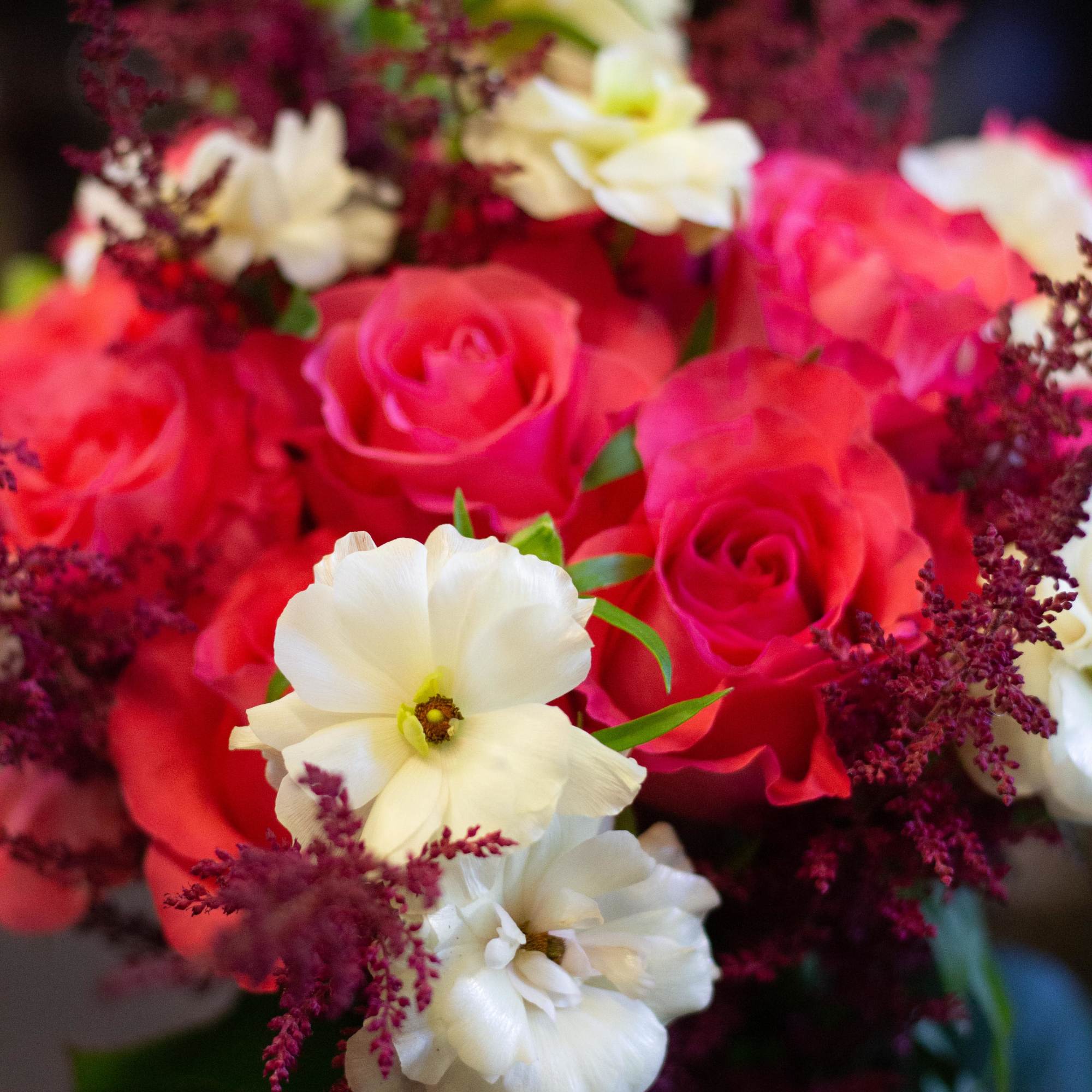 Bouquet of pink roses with white flowers and burgundy filler