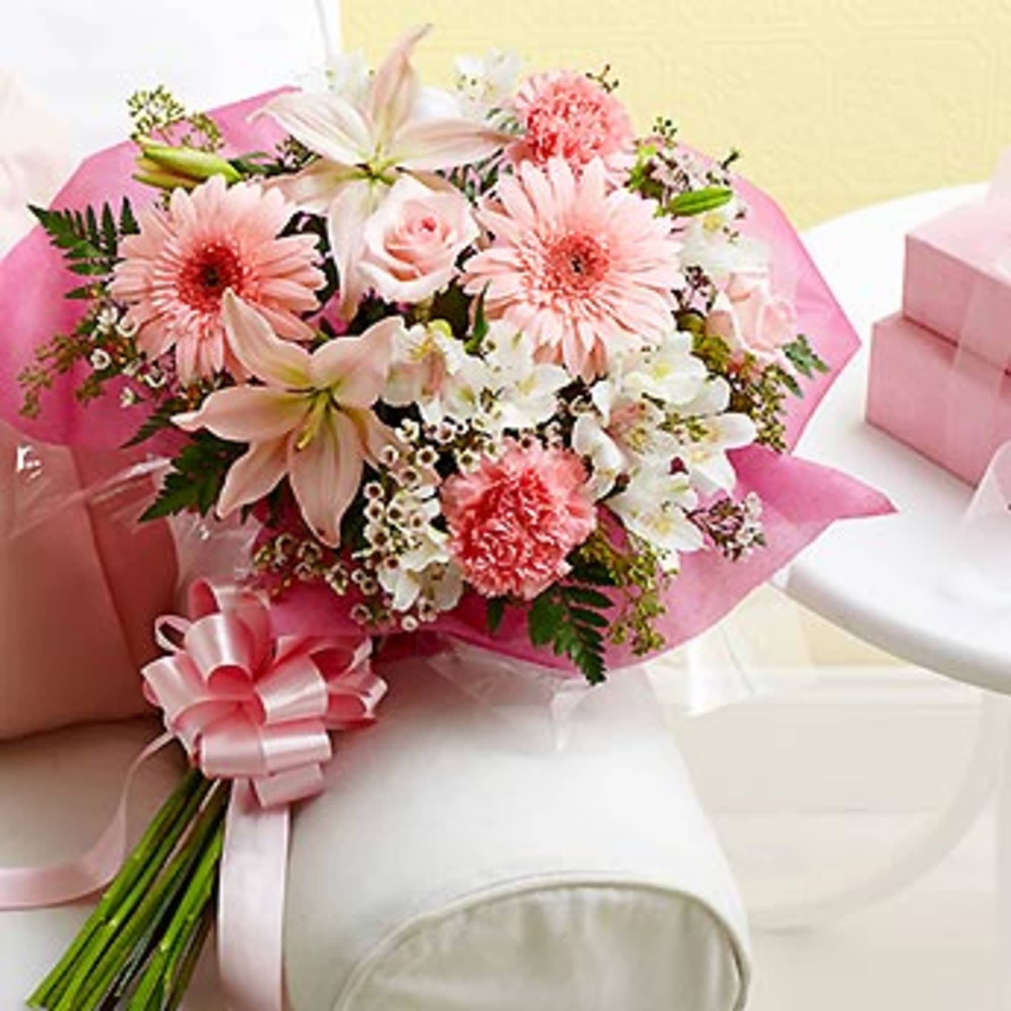 Pink and white mixed bouquet wrapped in pink paper with a ribbon