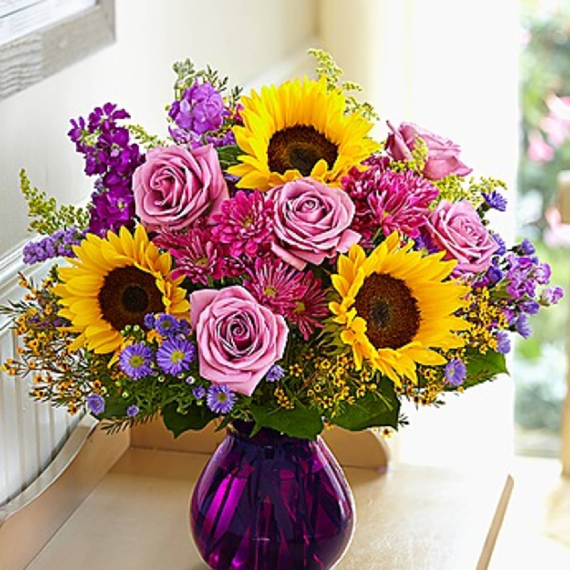 Bouquet of sunflowers, pink roses, and purple flowers in a purple vase, photo 2 of 3