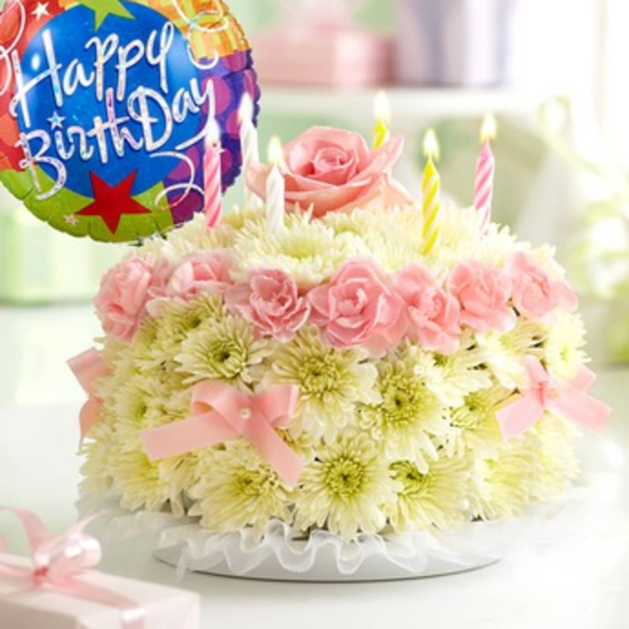 Pink rose and white daisy cake with birthday balloon and candles