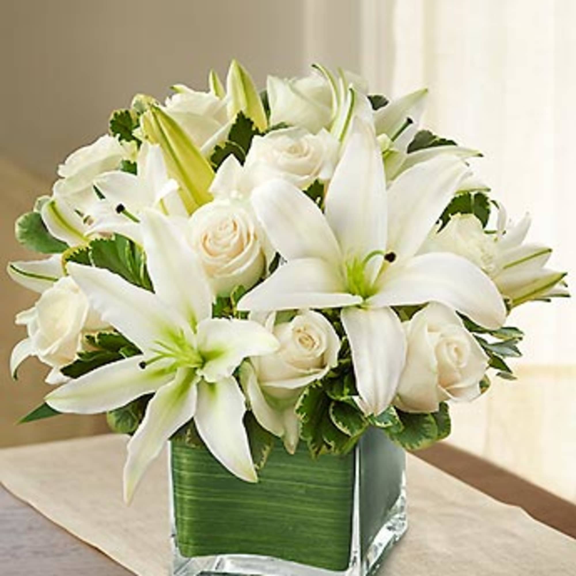 White lilies and roses arranged in a square glass vase, photo 3 of 3