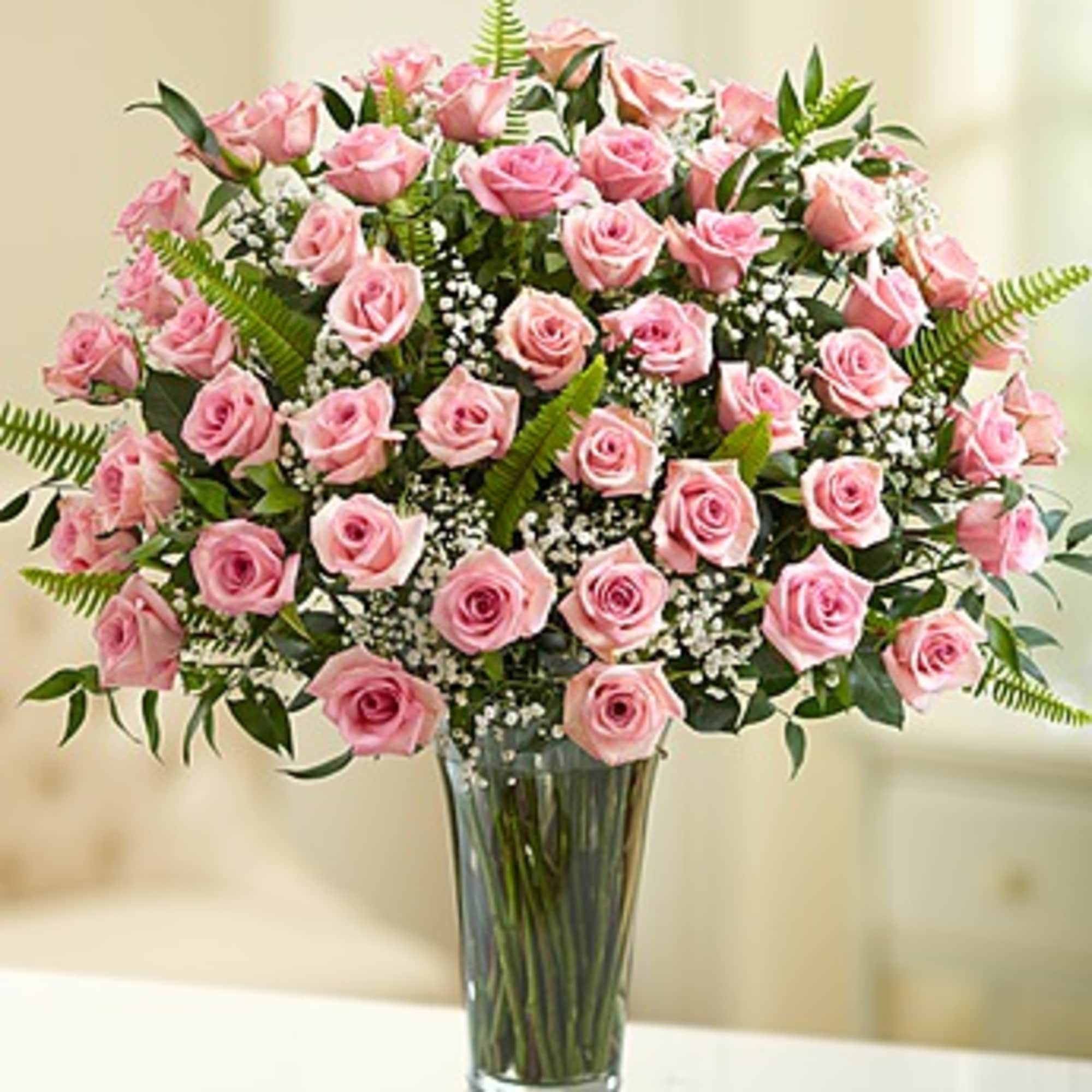 Pink roses arranged in a clear glass vase, photo 2 of 2