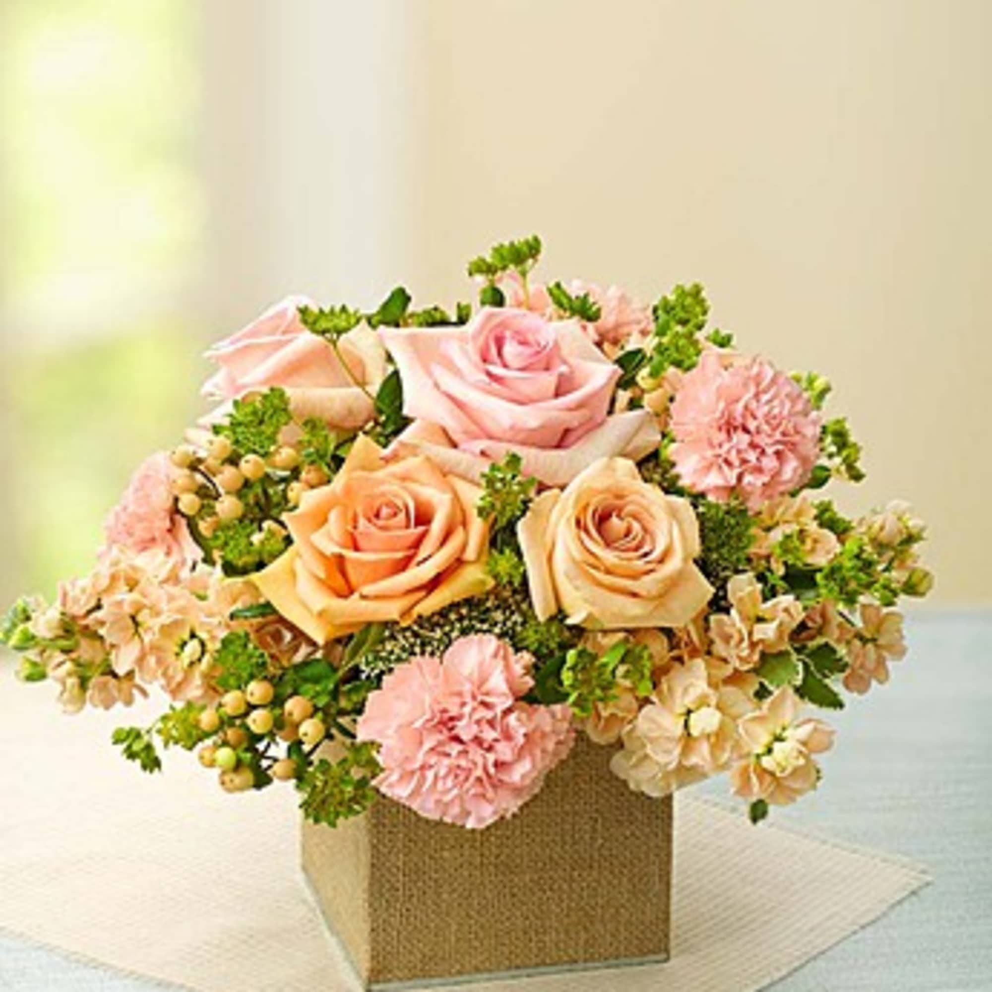 Pink and peach roses with carnations in a square box