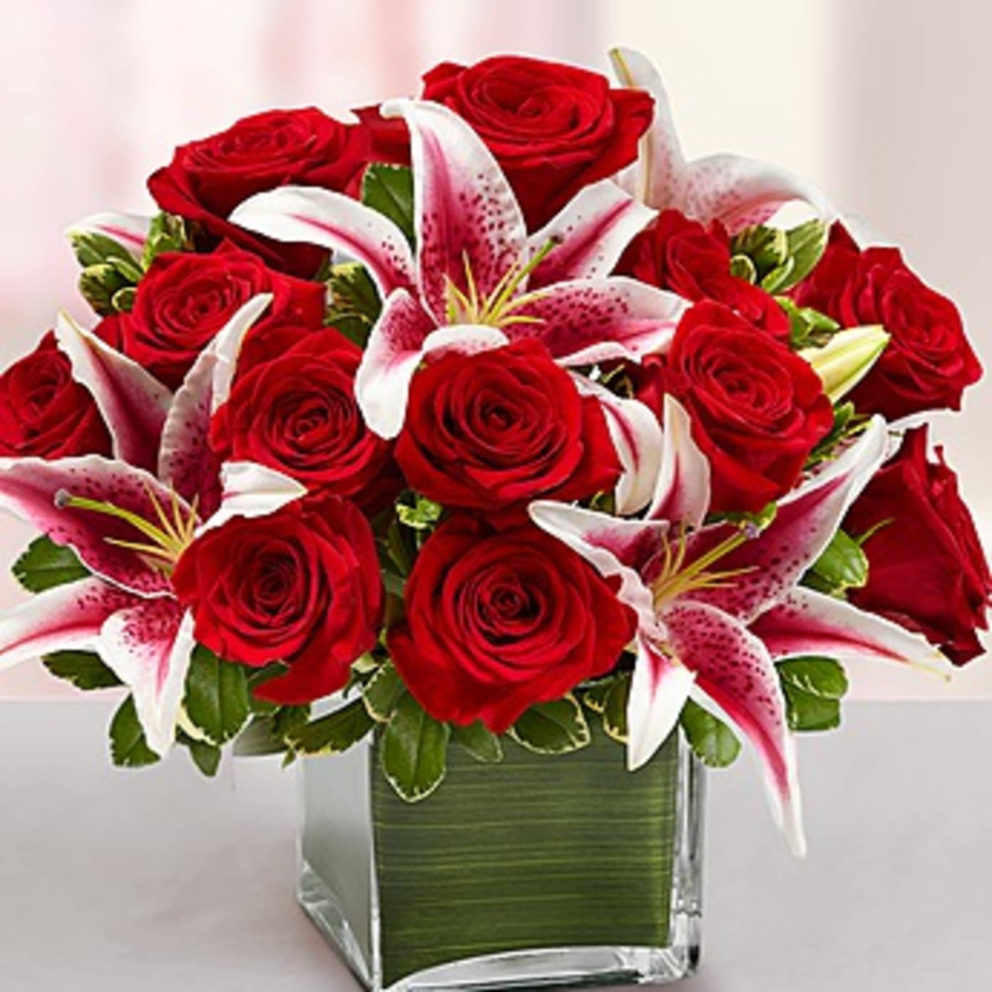 Red roses and pink lilies arranged in a square glass vase, photo 3 of 3