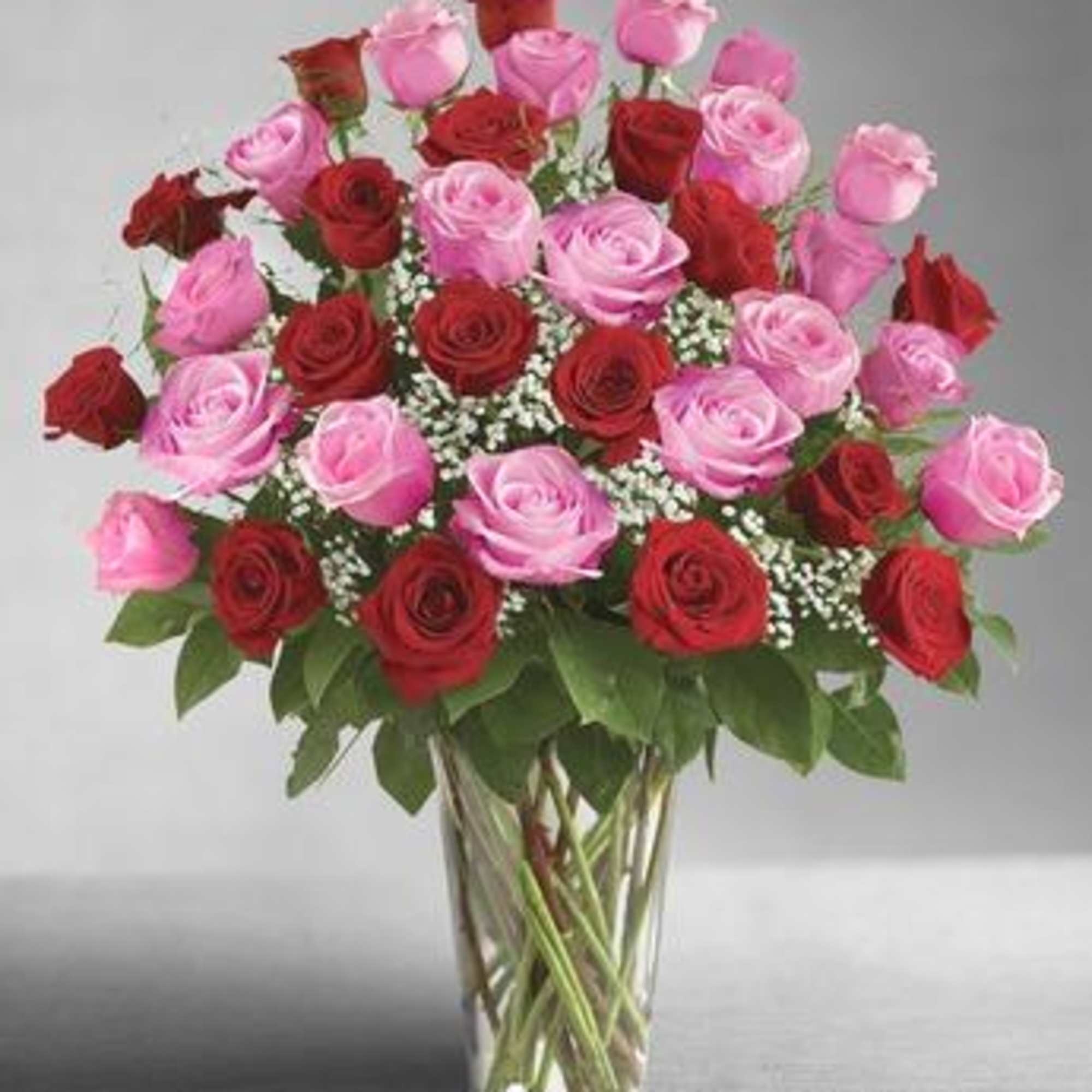 Bouquet of red and pink roses in a clear glass vase, photo 2 of 3