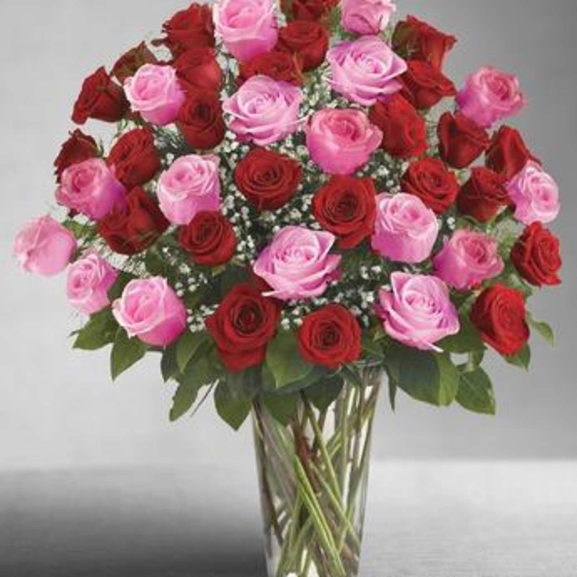 Bouquet of pink and red roses in a clear glass vase