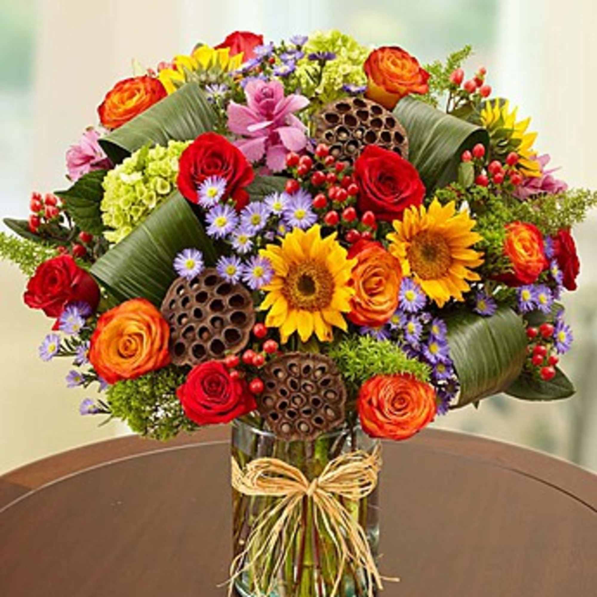 Mixed bouquet of roses and sunflowers in a glass vase