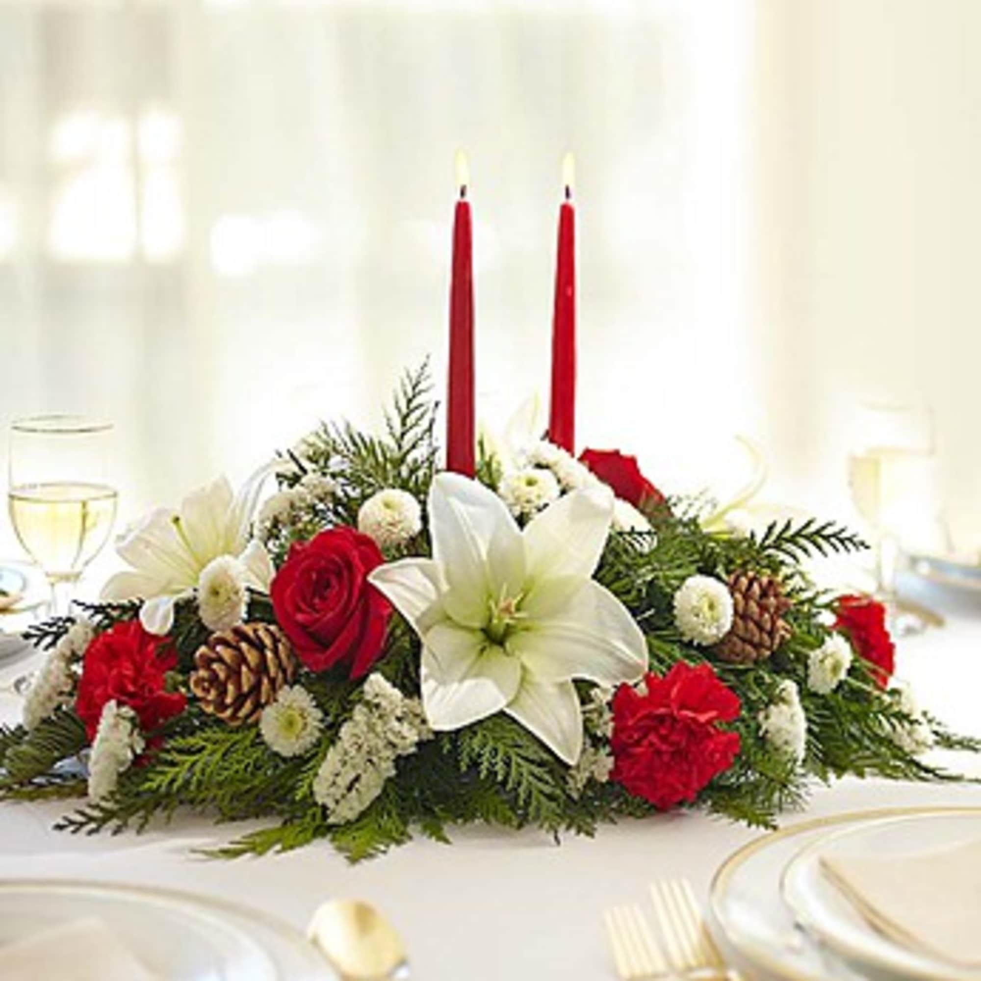 Holiday centerpiece with red candles, white lily, and red roses