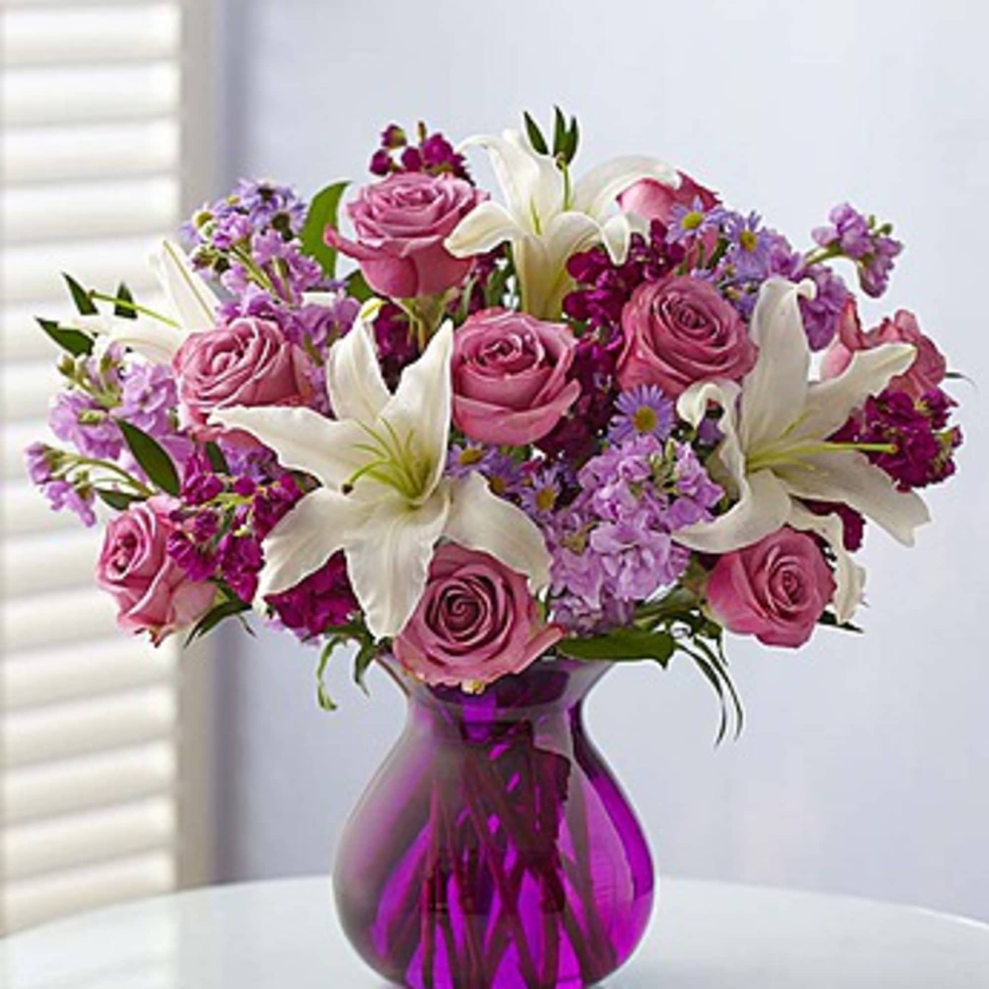 Pink roses and white lilies in a purple glass vase, photo 2 of 3