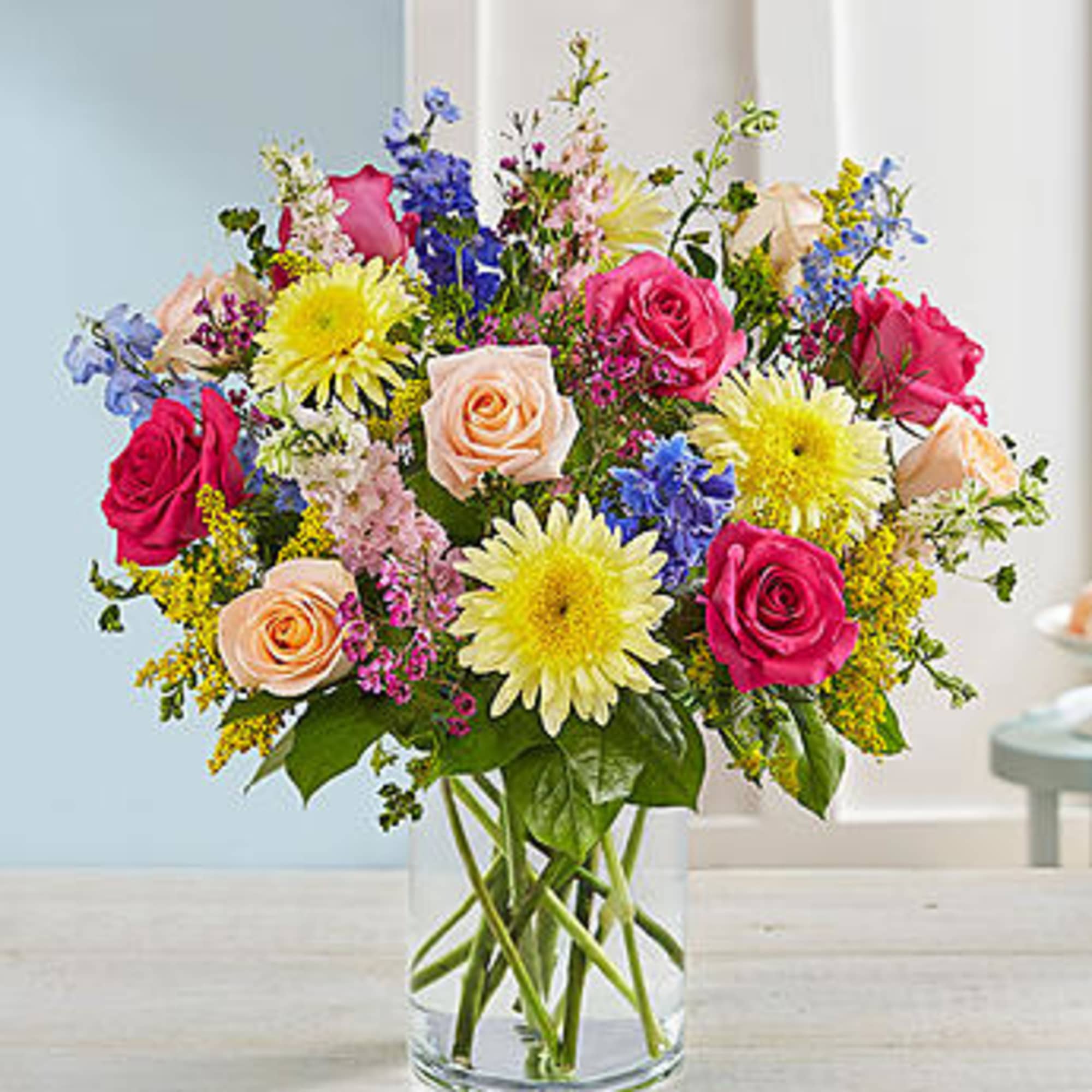 Mixed bouquet of roses and daisies in a clear glass vase, photo 2 of 3