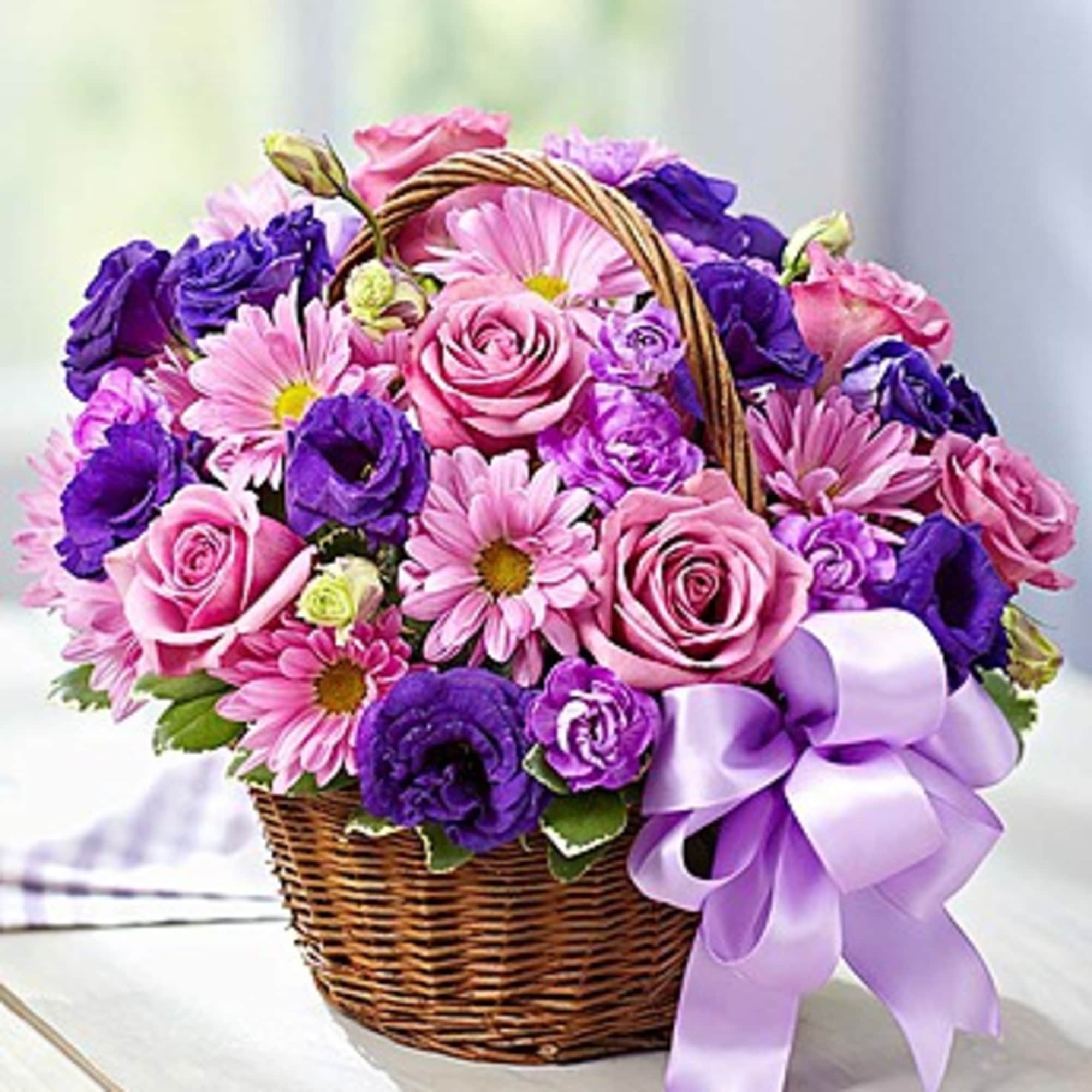 Pink and purple flowers in a wicker basket with a lavender ribbon, photo 3 of 3