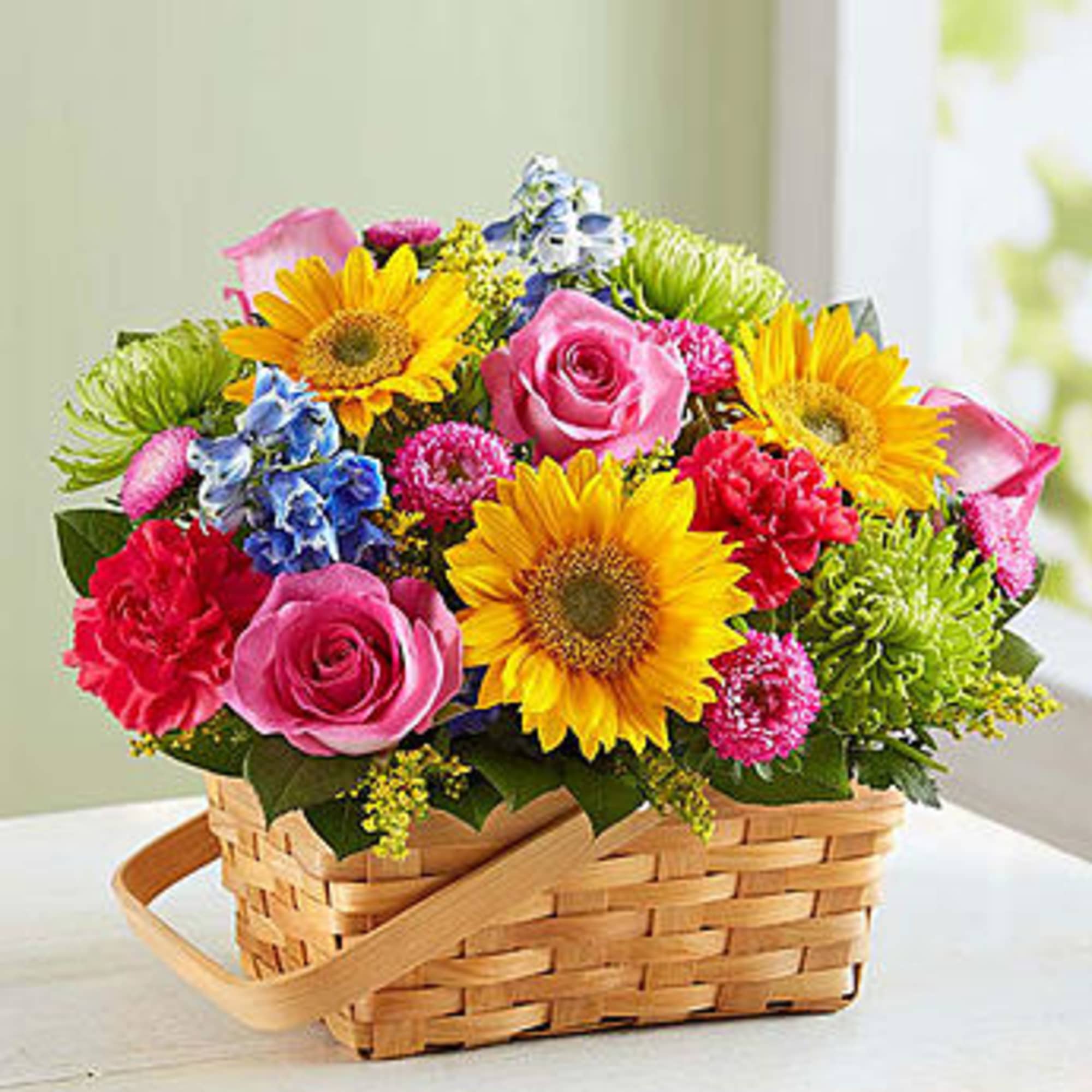 Basket of mixed flowers with sunflowers, pink roses, and carnations