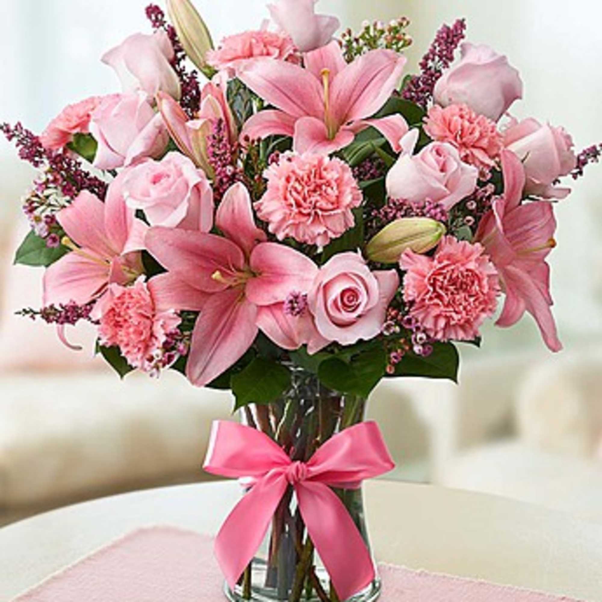 Pink lilies and roses in a glass vase with a pink ribbon, photo 2 of 3