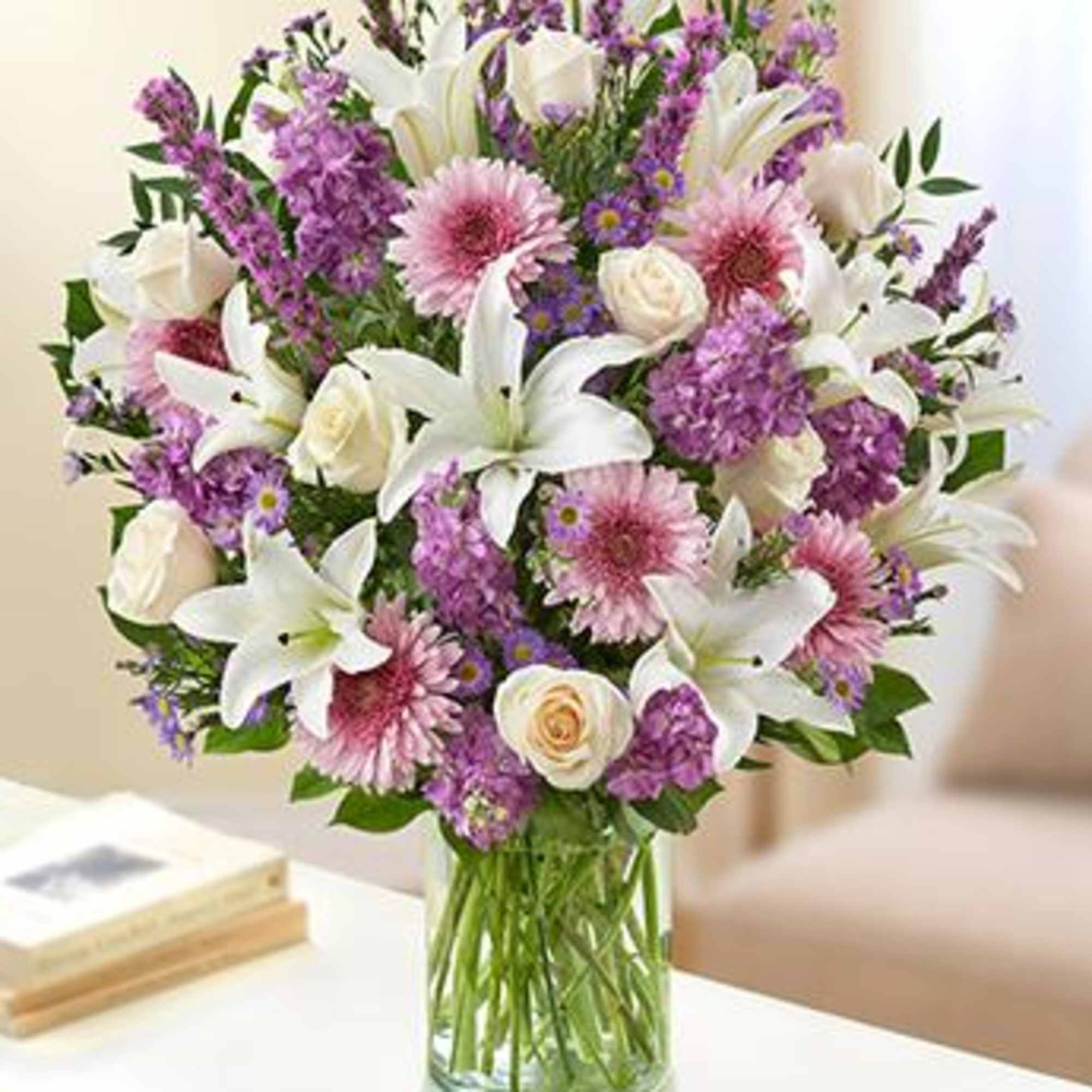 Bouquet of white lilies, pink daisies, and purple flowers in a glass vase, photo 2 of 2