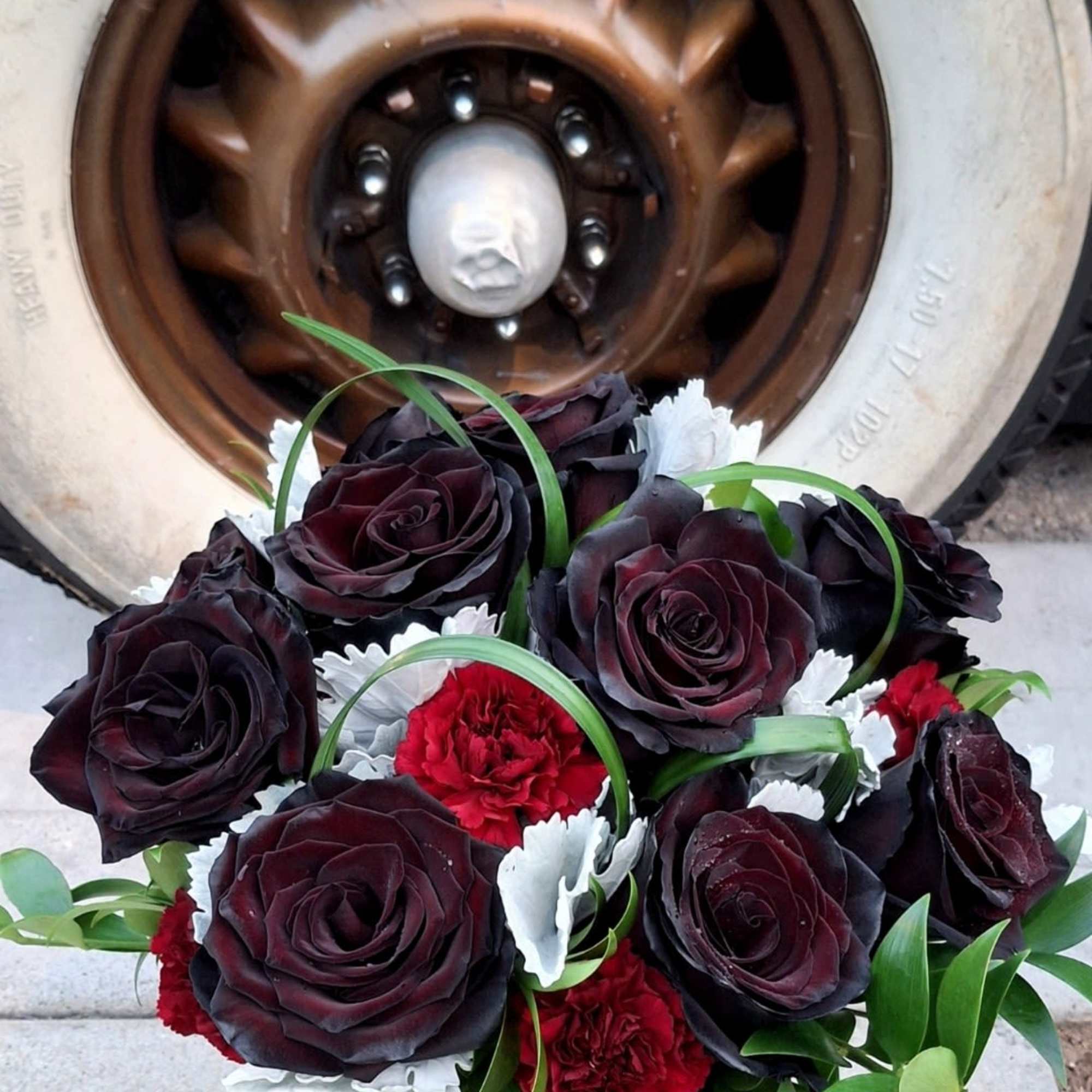 Bouquet of dark red roses and red carnations in a silver vase
