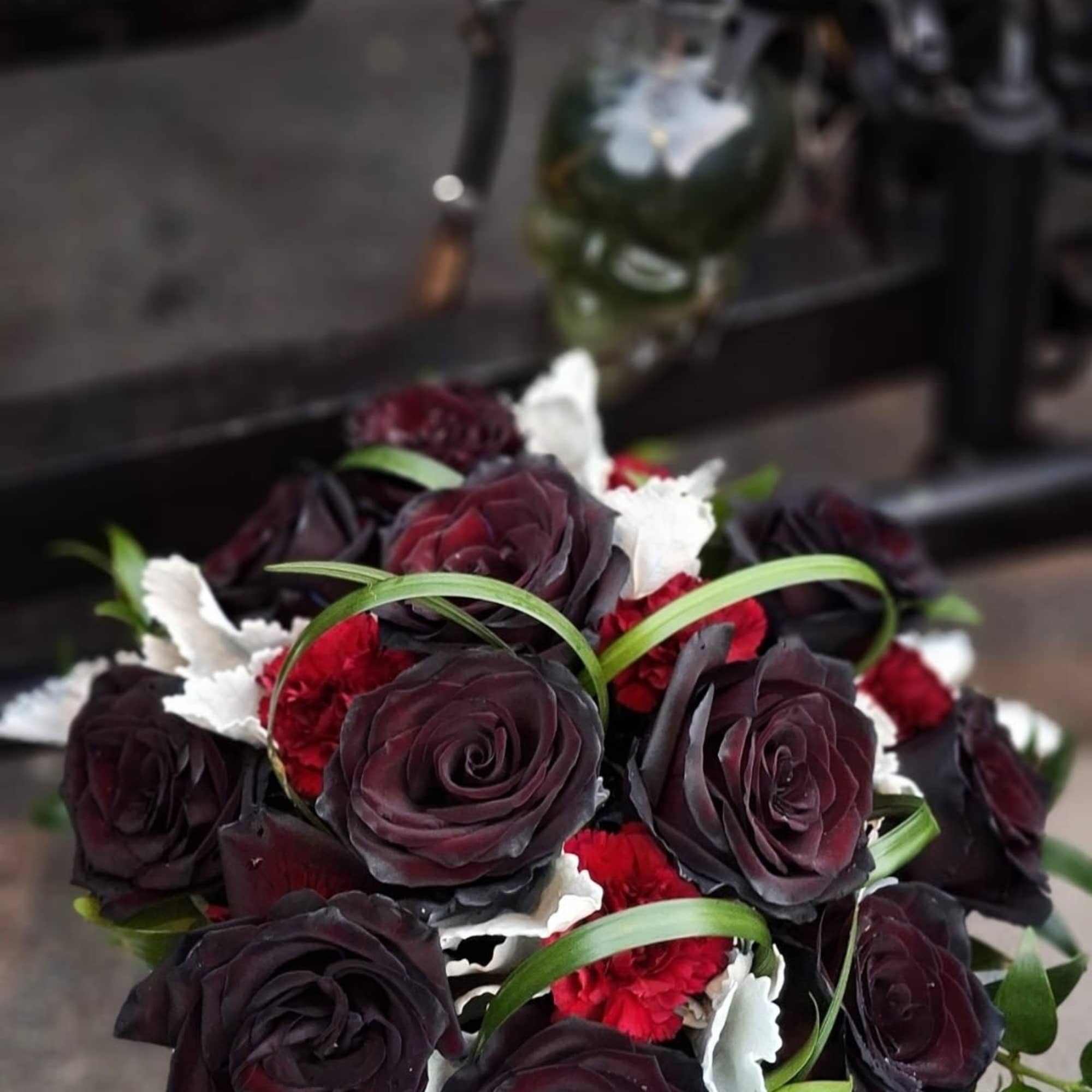 Bouquet of dark red roses with red carnations and white accents