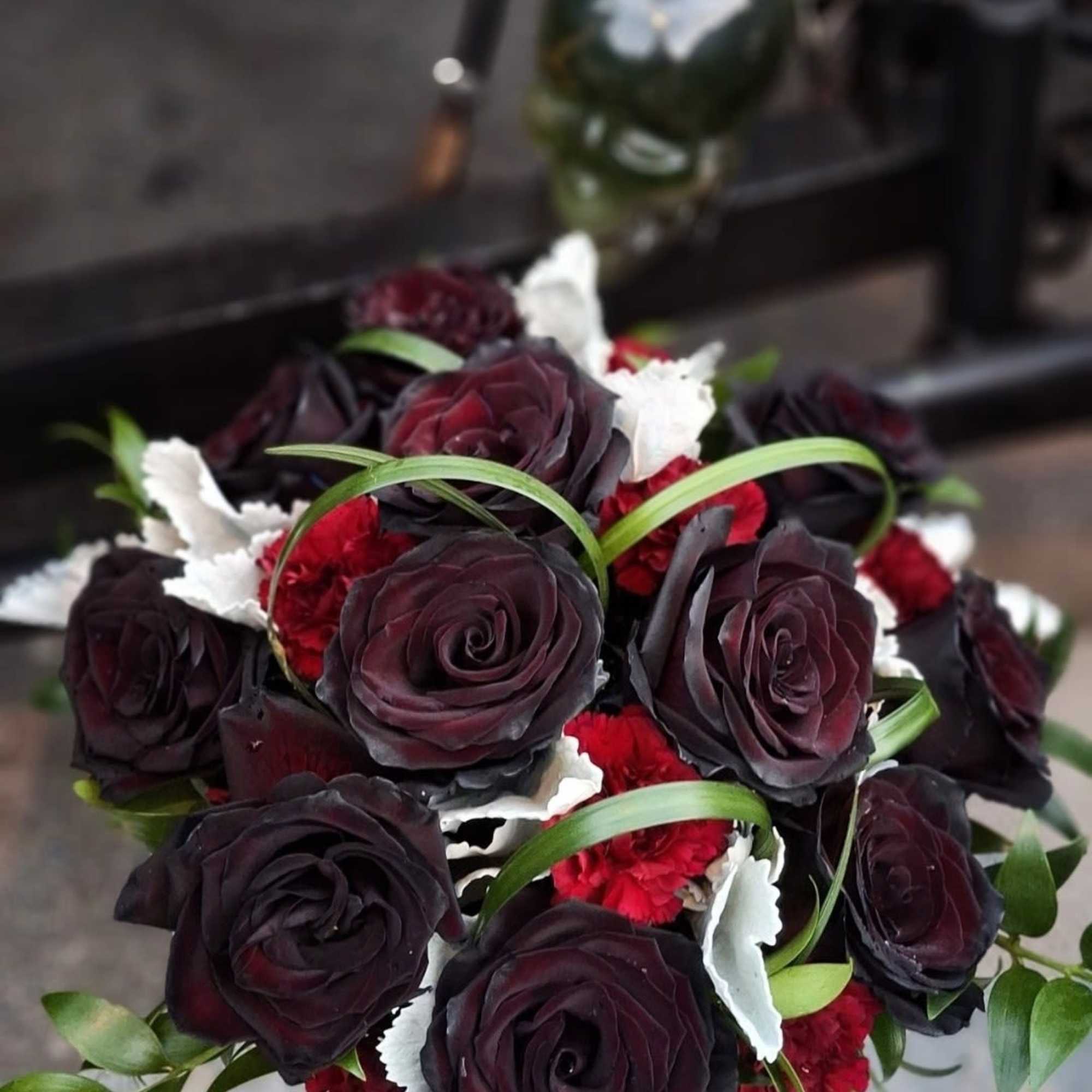 Bouquet of dark red roses with red carnations and white accents
