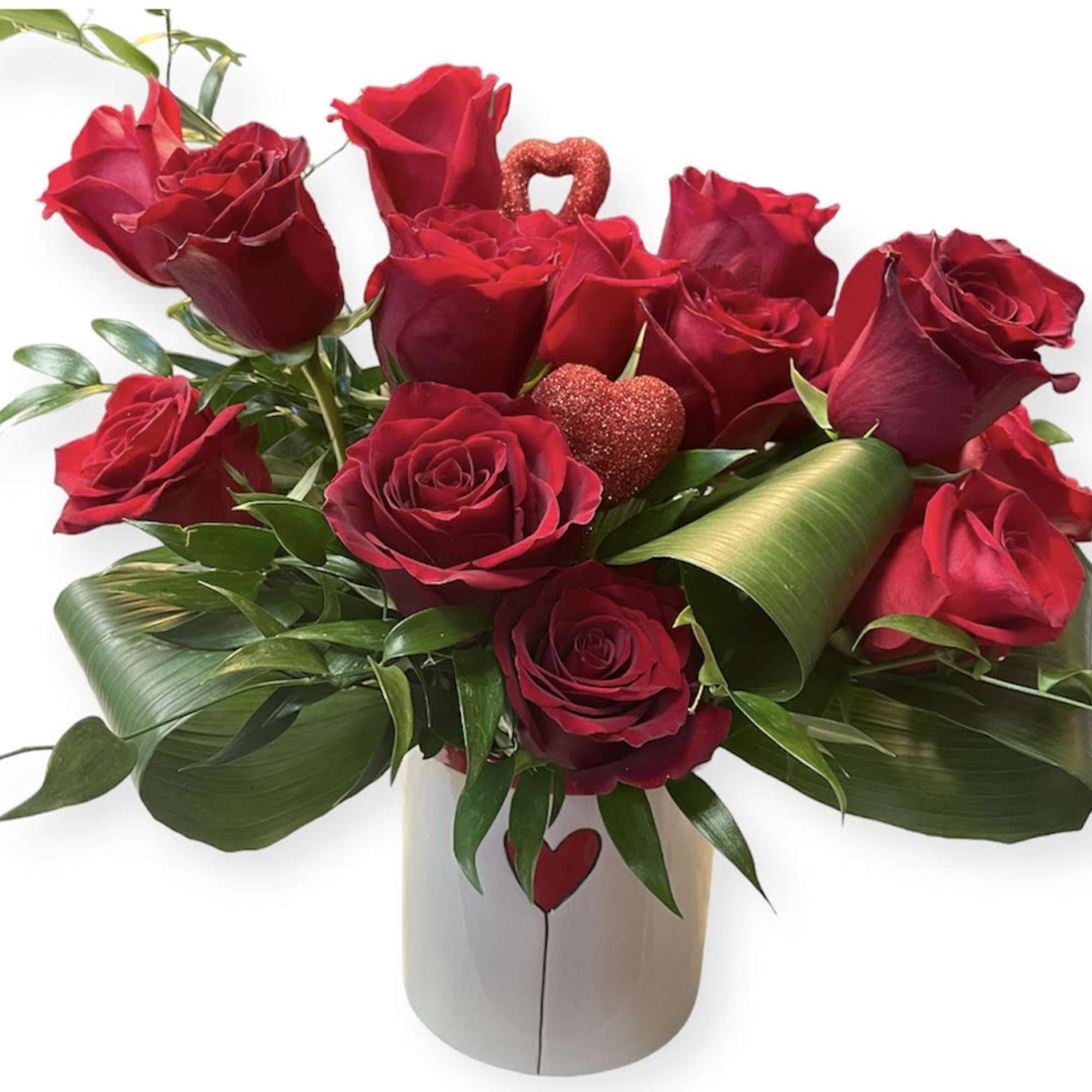 Red roses arranged in a white vase with heart accents