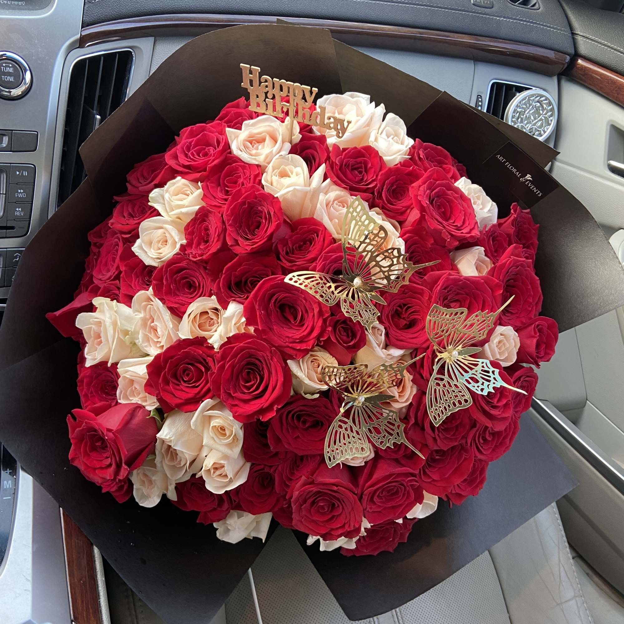 Bouquet of red and blush roses with butterfly picks and a Happy Birthday topper