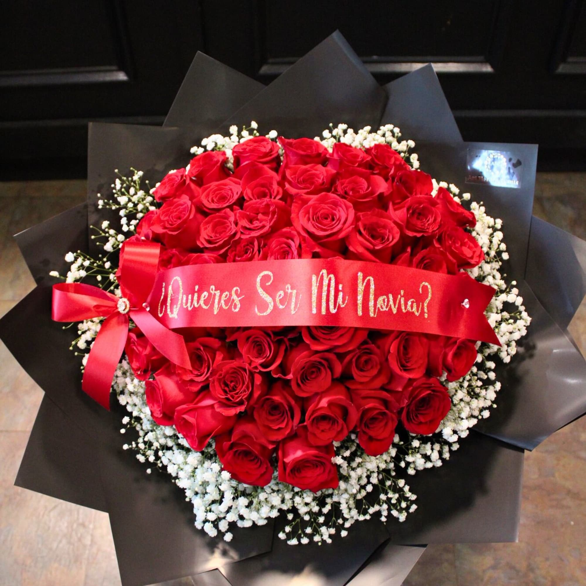 Bouquet of red roses with white baby's breath and a red ribbon