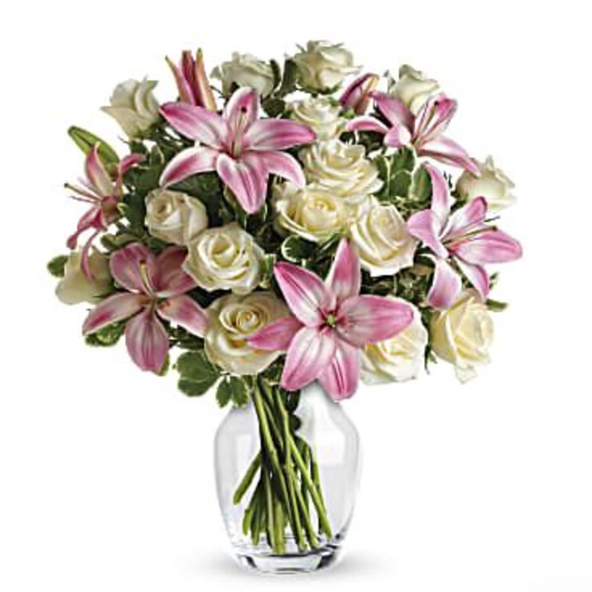 Bouquet of pink lilies and white roses in a clear glass vase