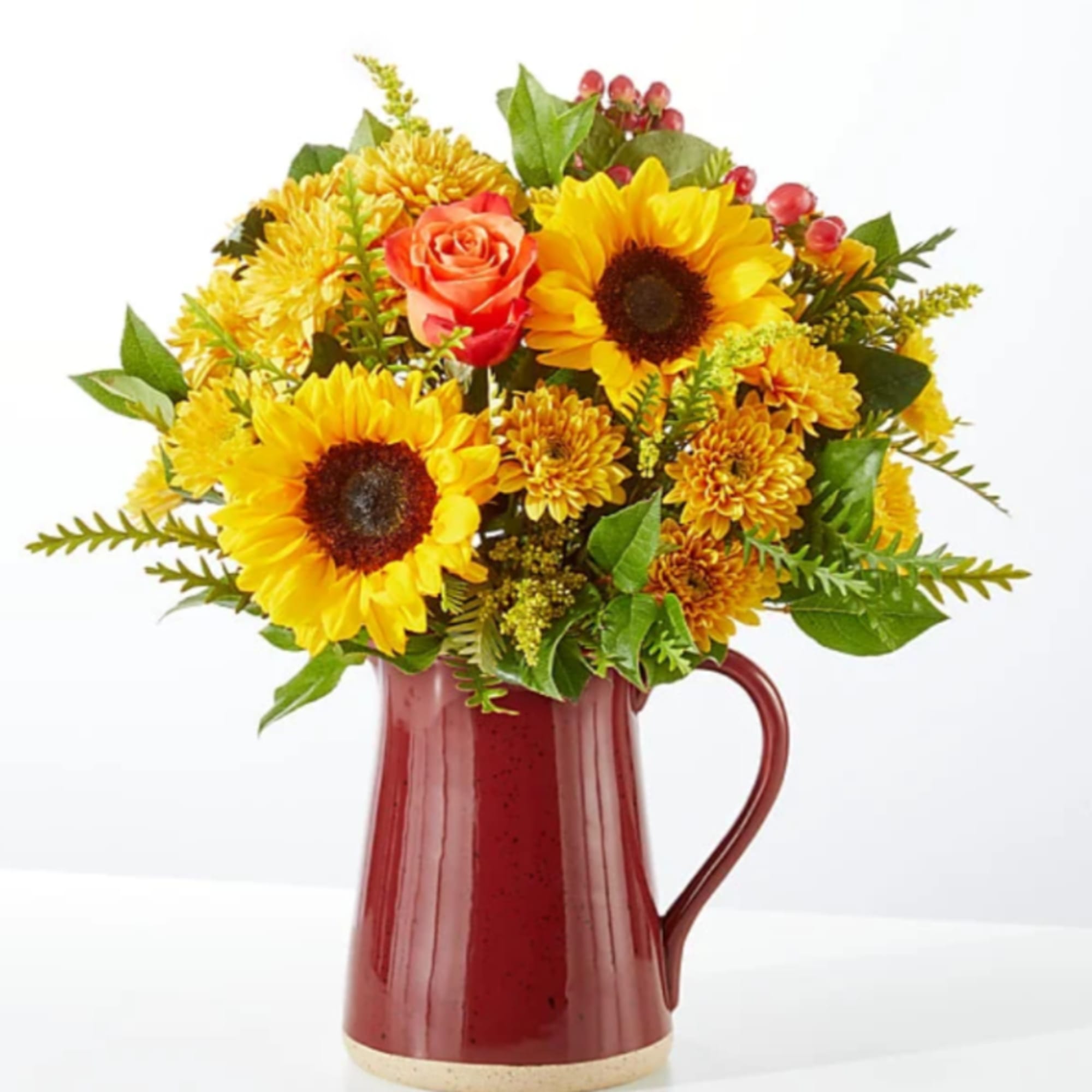 Sunflower and rose bouquet in a red ceramic pitcher
