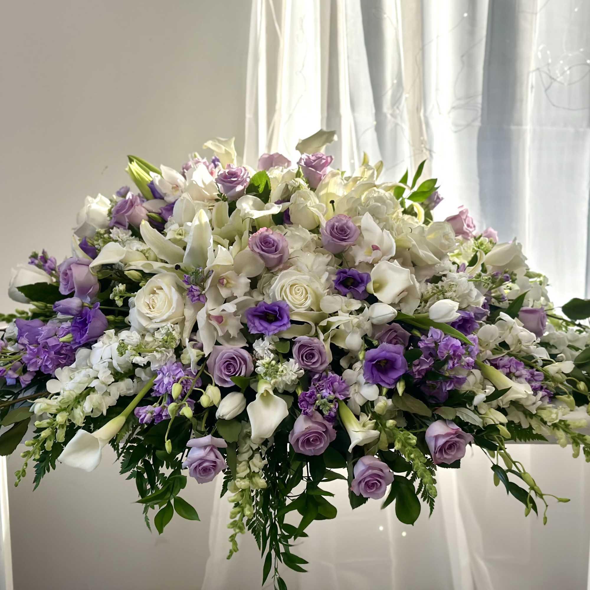 Large white and lavender floral arrangement on a table