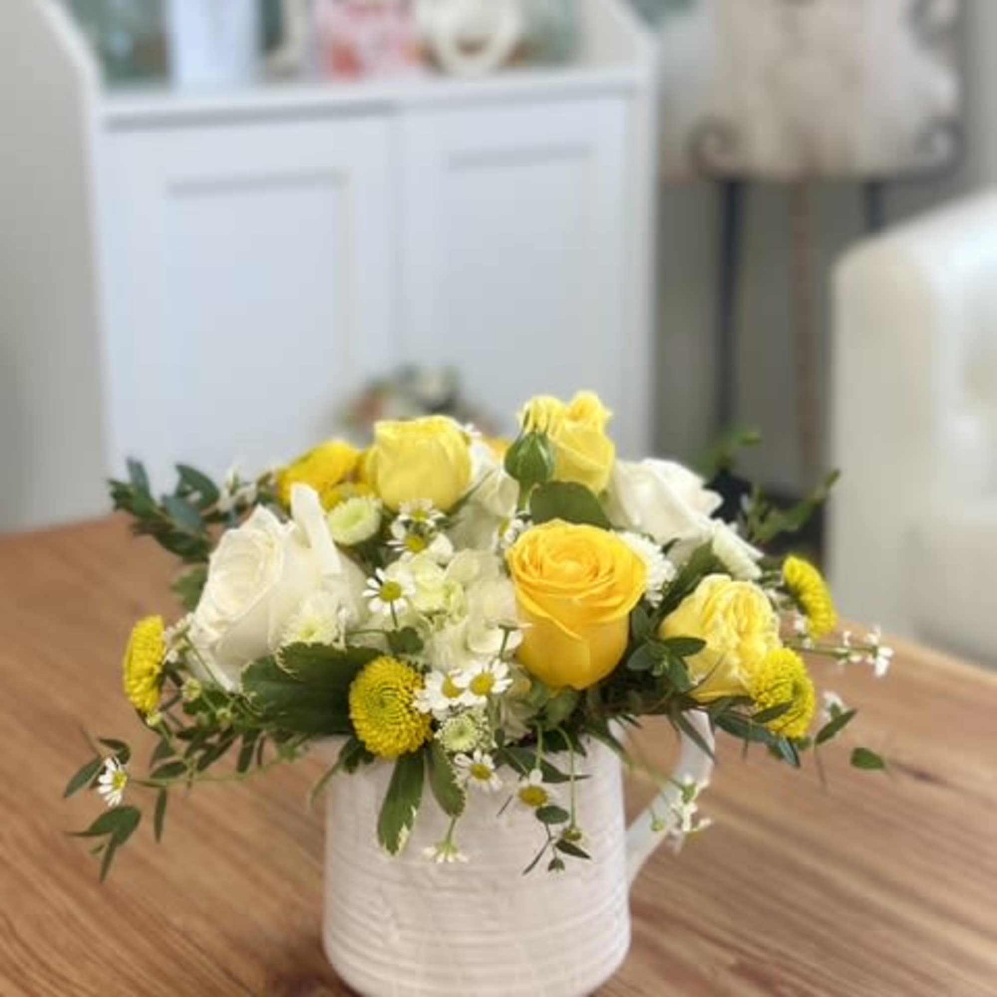 Yellow and white rose bouquet in a white ceramic vase