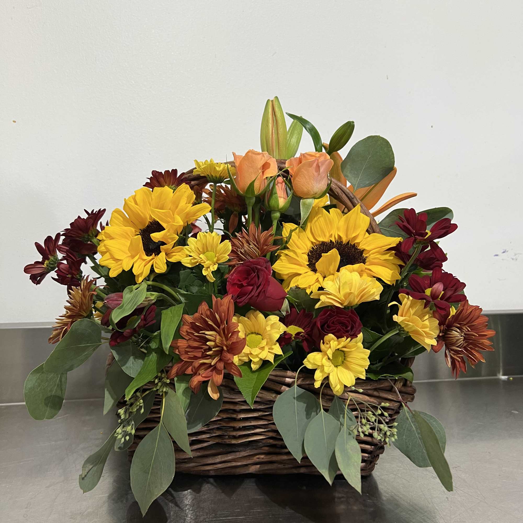 Gorgeous shades of fall. Sunflowers, lilies, spray roses, and assorted daisy poms.