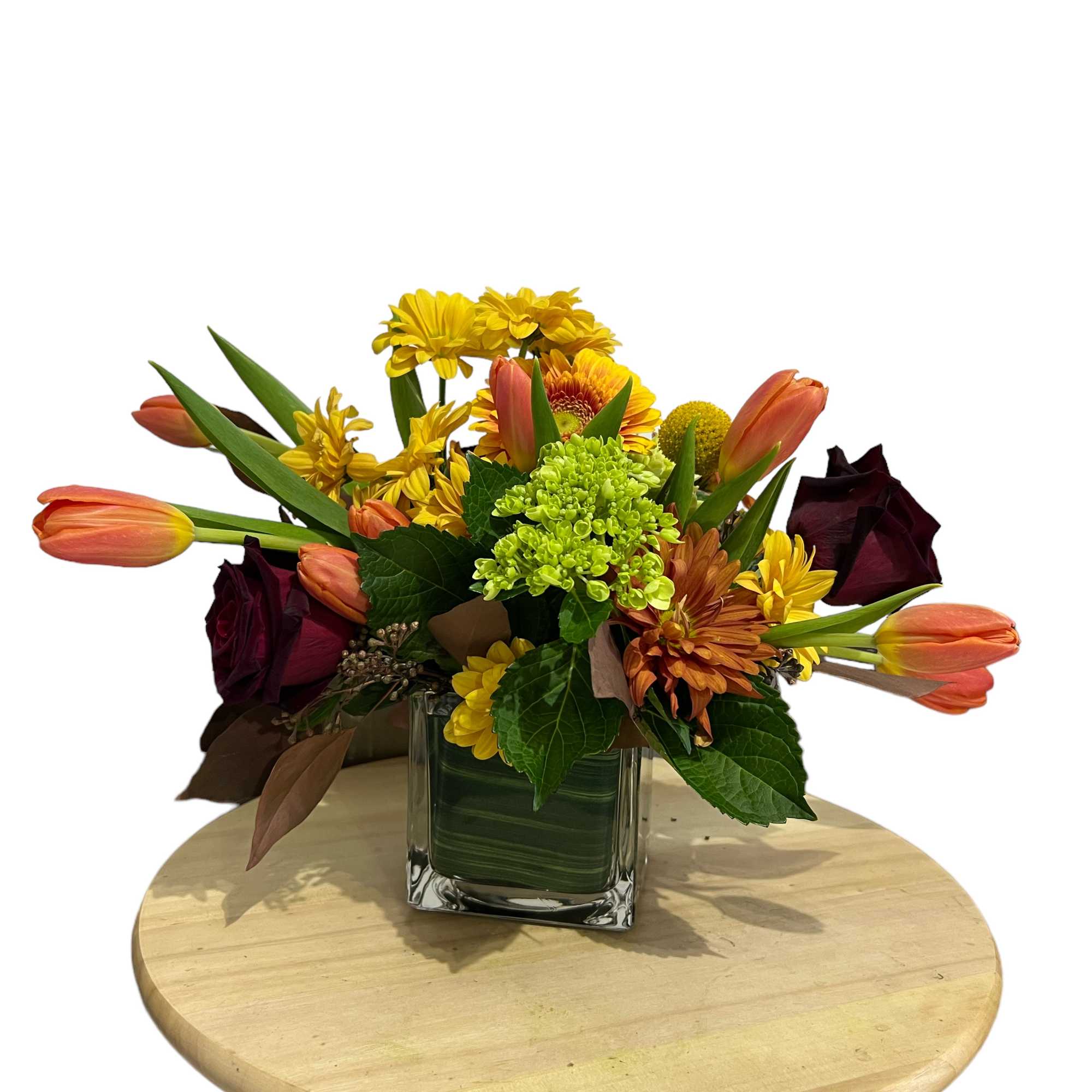 Mixed bouquet in a square glass vase with yellow, orange, and burgundy flowers