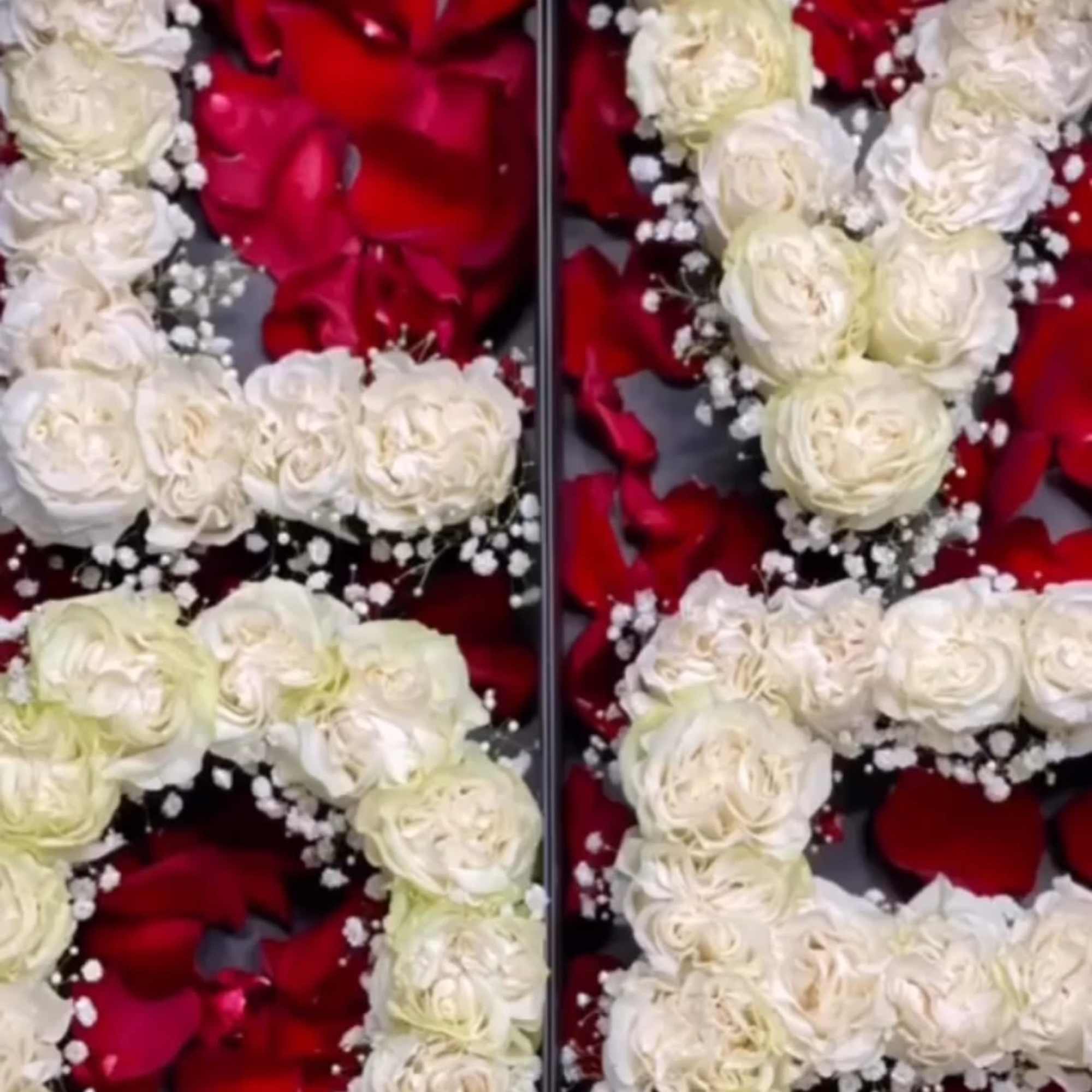 White rose garlands arranged over red rose petals