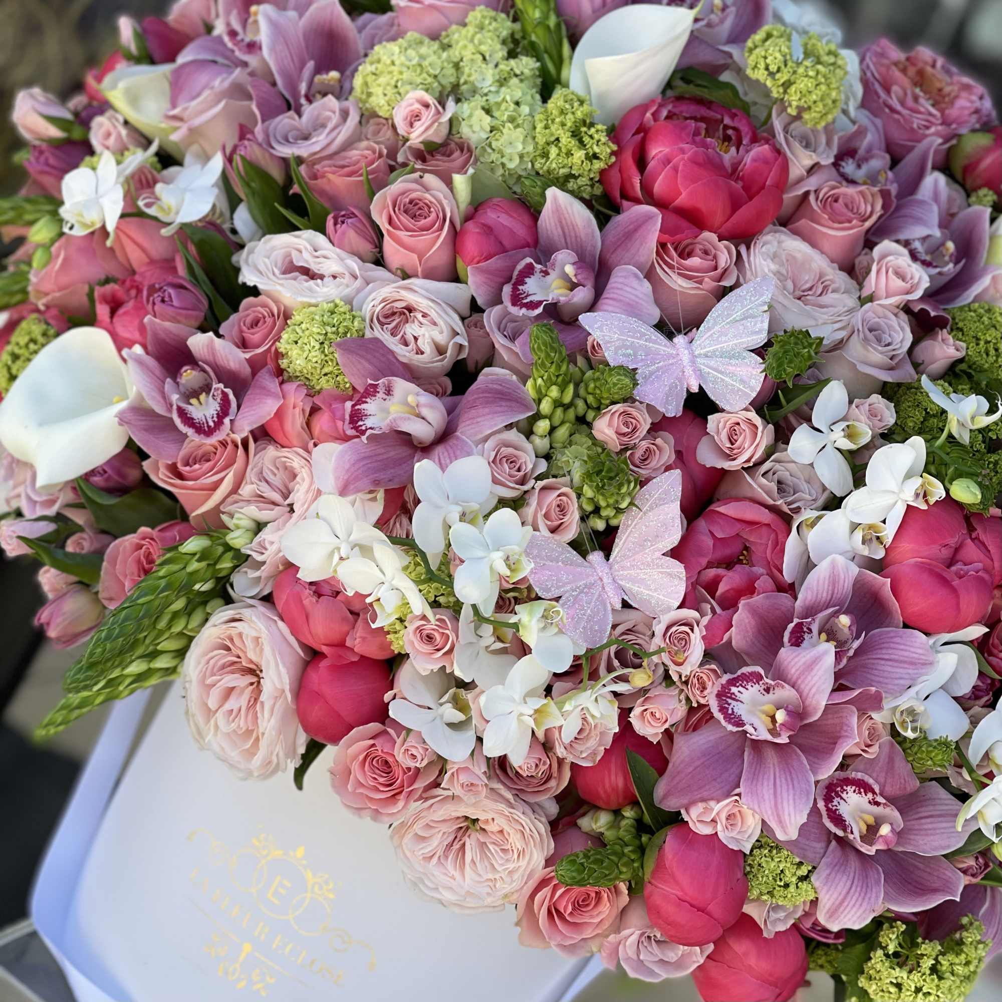 Bouquet of pink roses, orchids, and white calla lilies with green accents