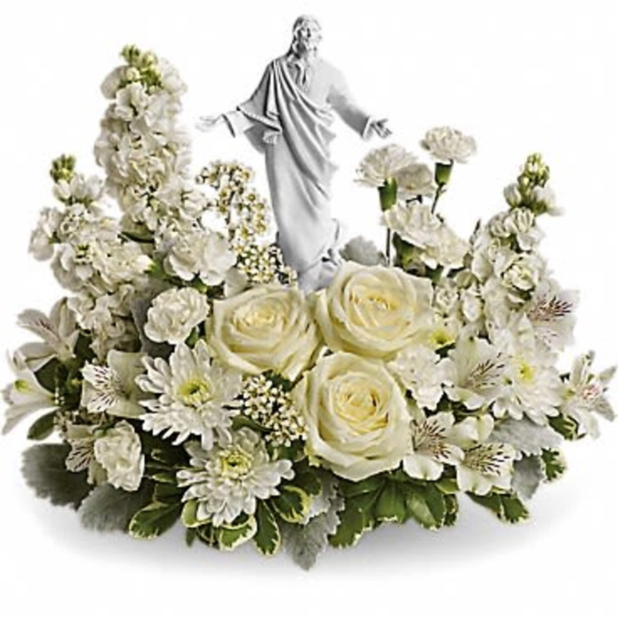 White floral arrangement with a small religious statue in the center