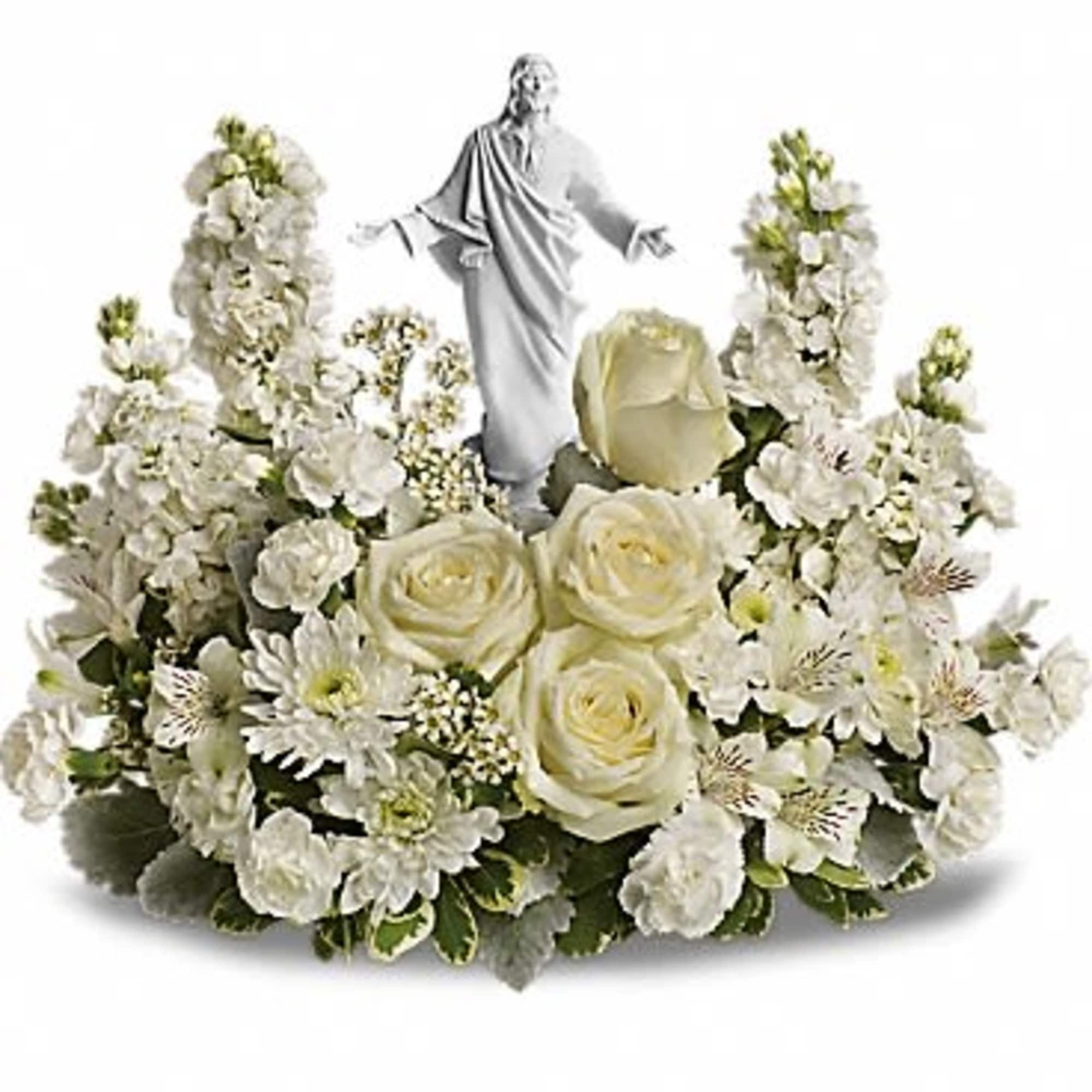 White floral arrangement with a small religious statue in the center