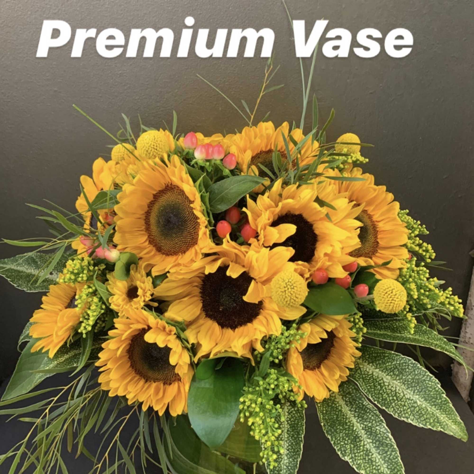 Sunflower arrangement in a glass vase with yellow accents
