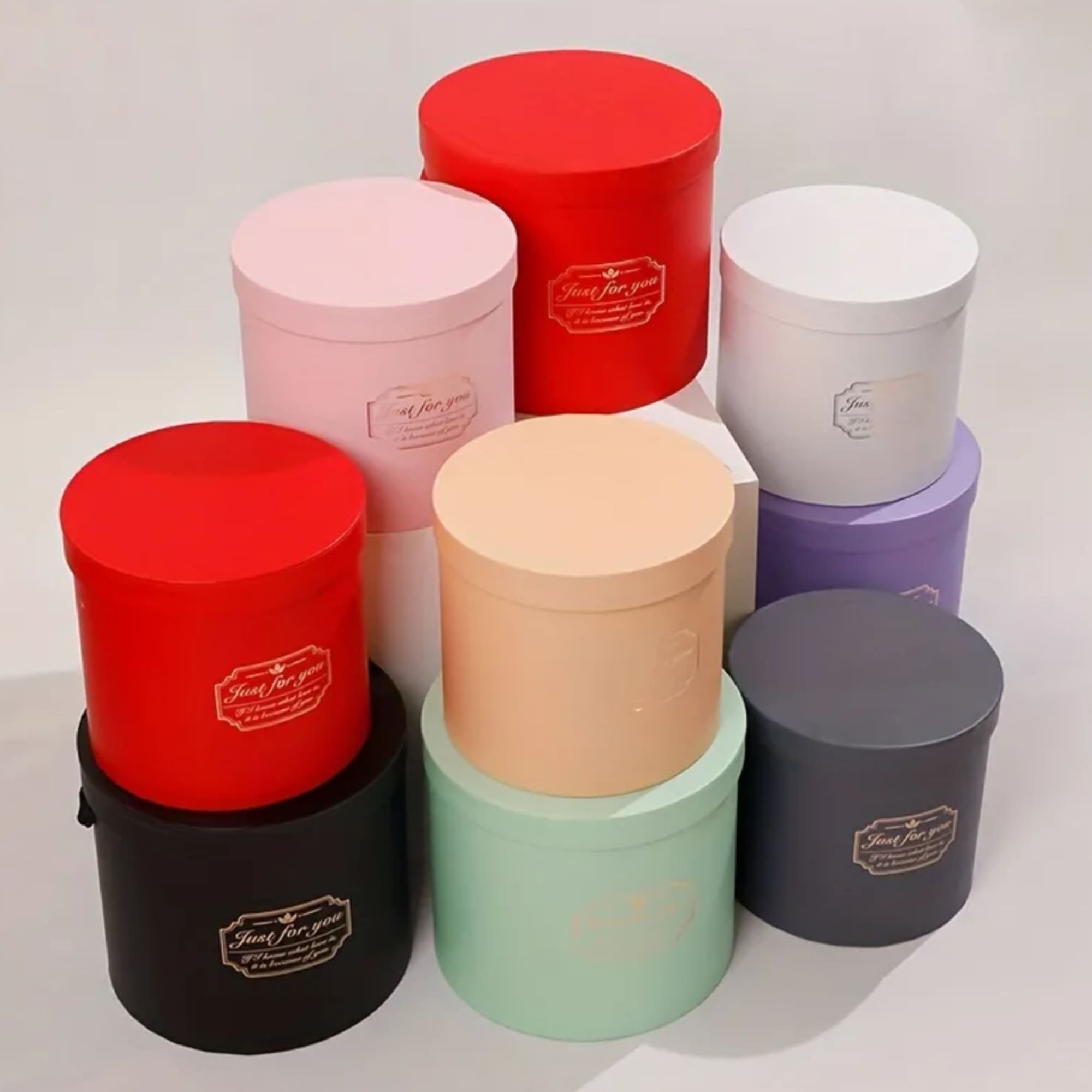 Stacked round gift boxes in assorted colors on a white background