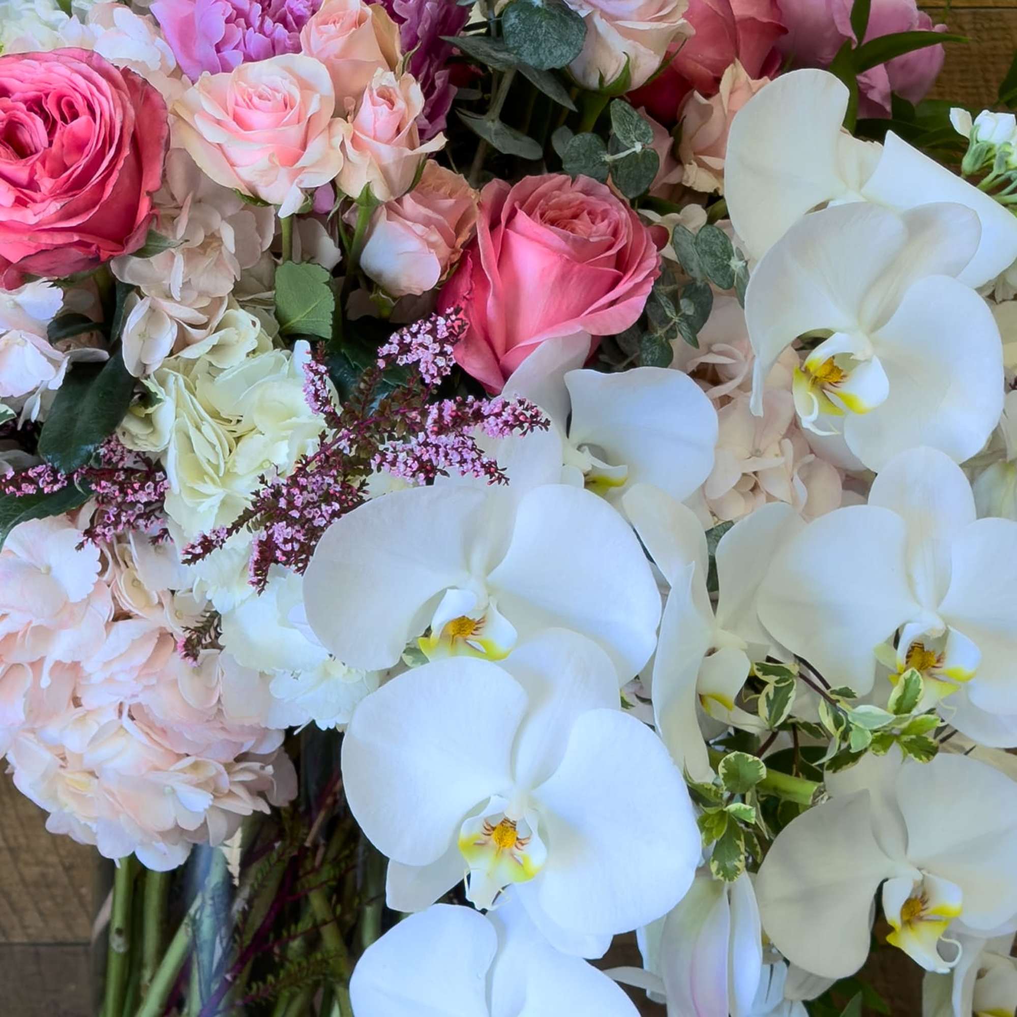 Bouquet of pink roses, pale hydrangeas, and white orchids