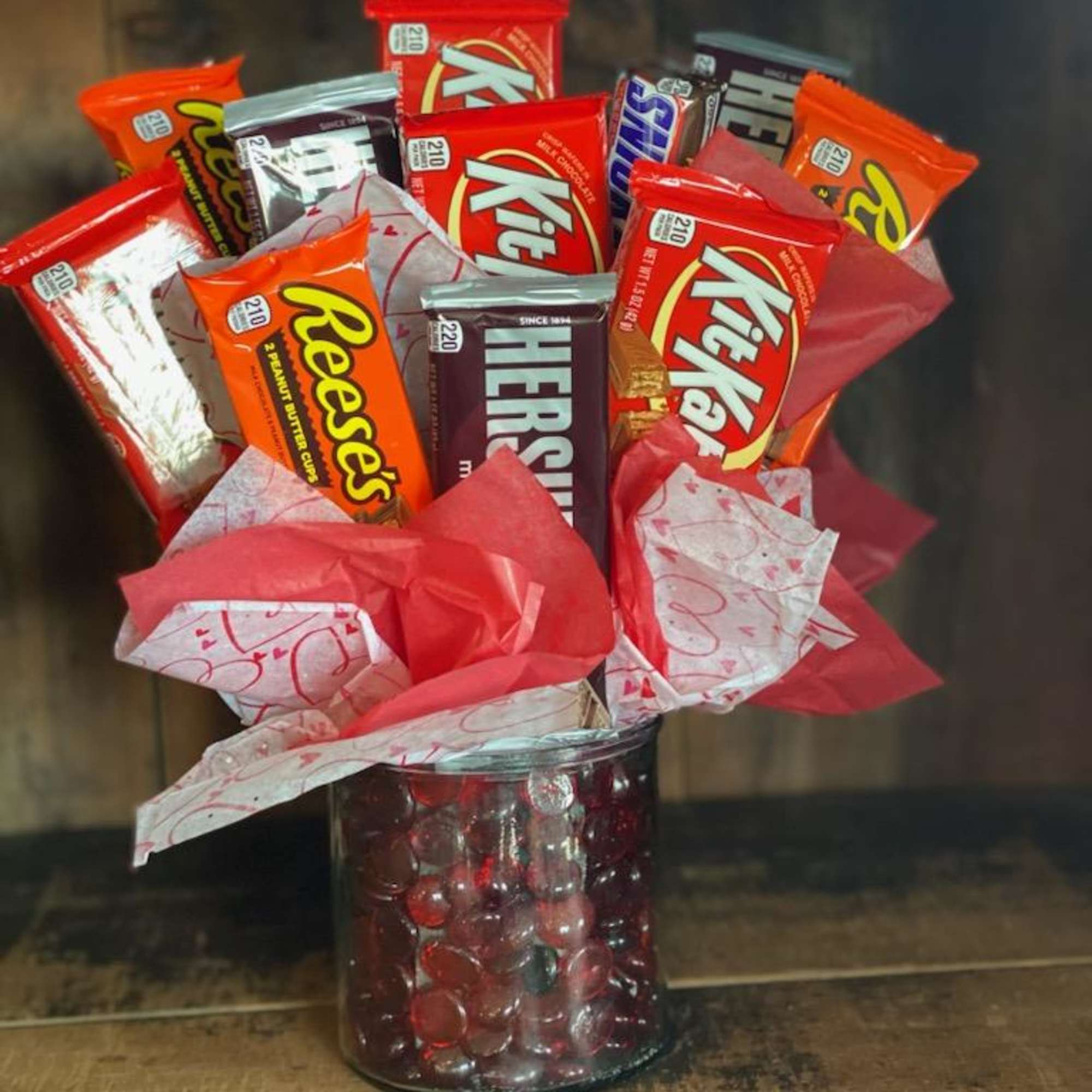 Candy bouquet in a glass jar with red and pink wrapping