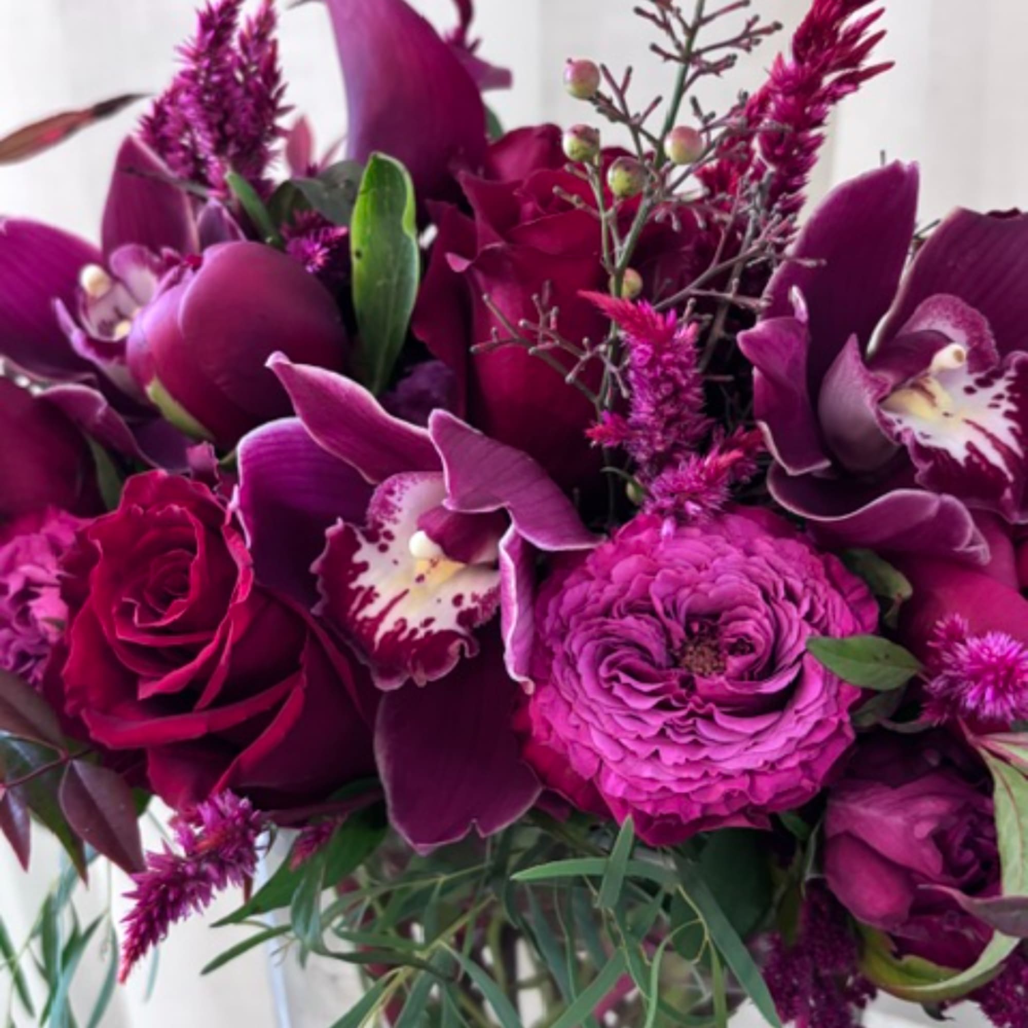 Purple bouquet with roses, orchids, and ranunculus