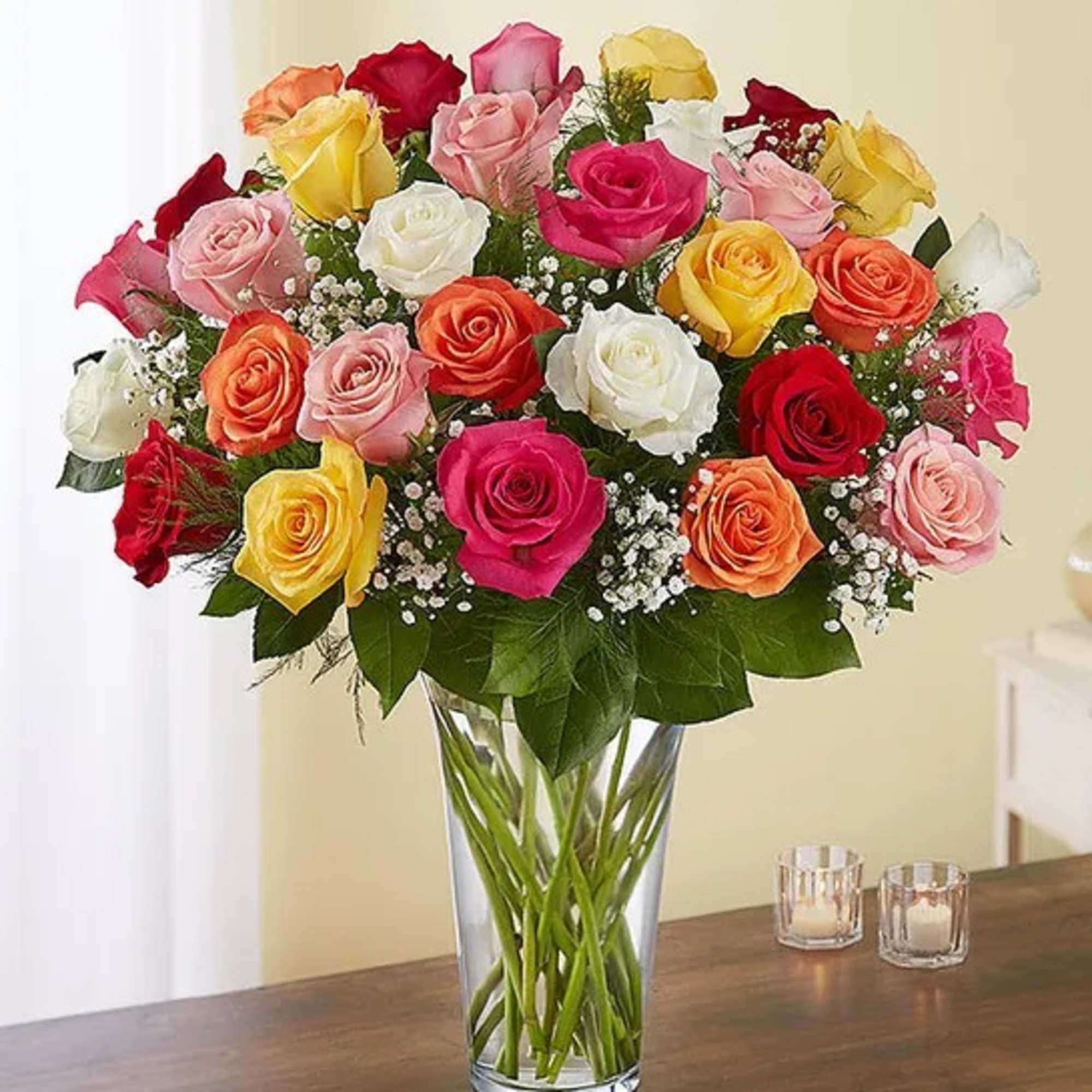 Mixed roses in many colors arranged in a clear glass vase