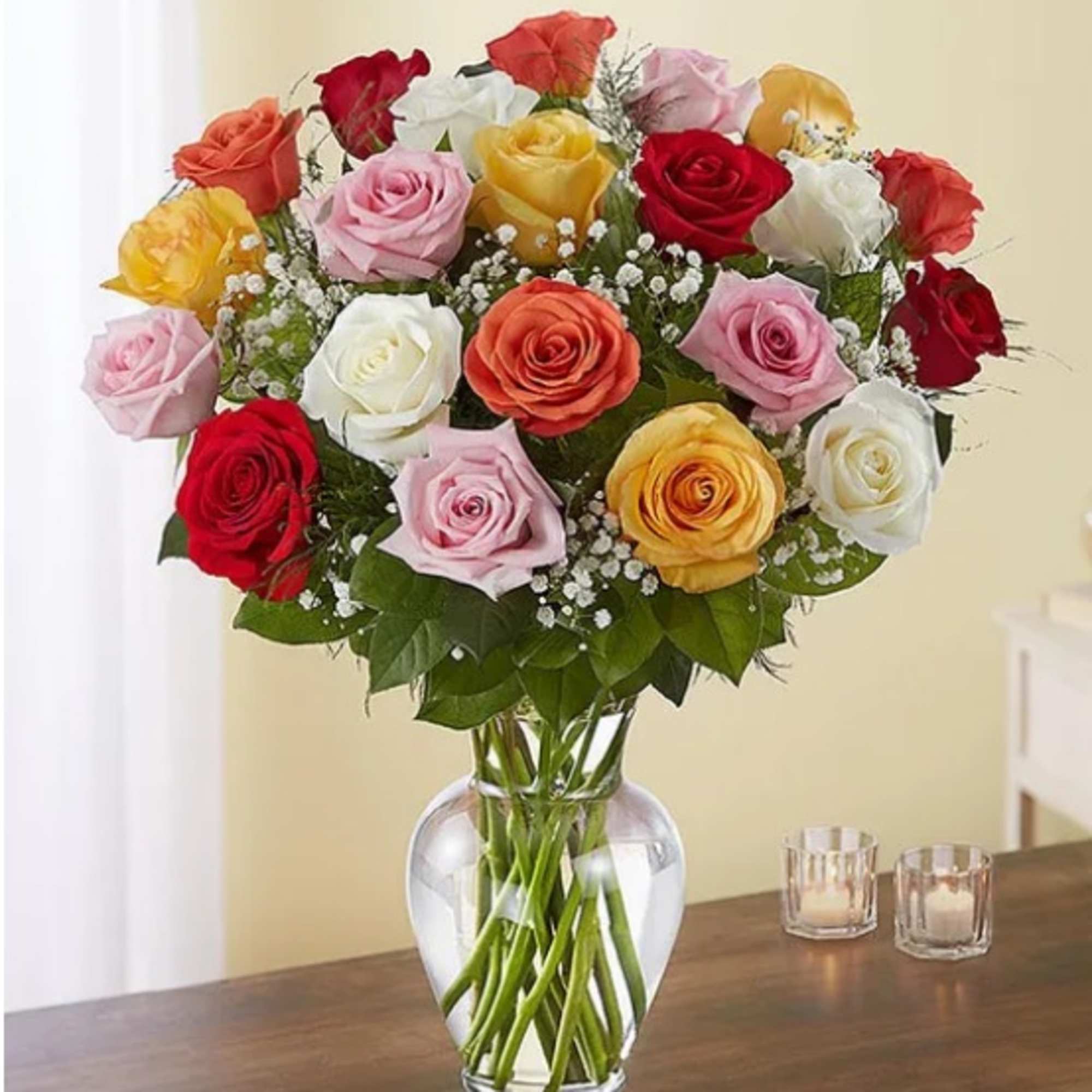 Mixed roses in a clear glass vase on a table