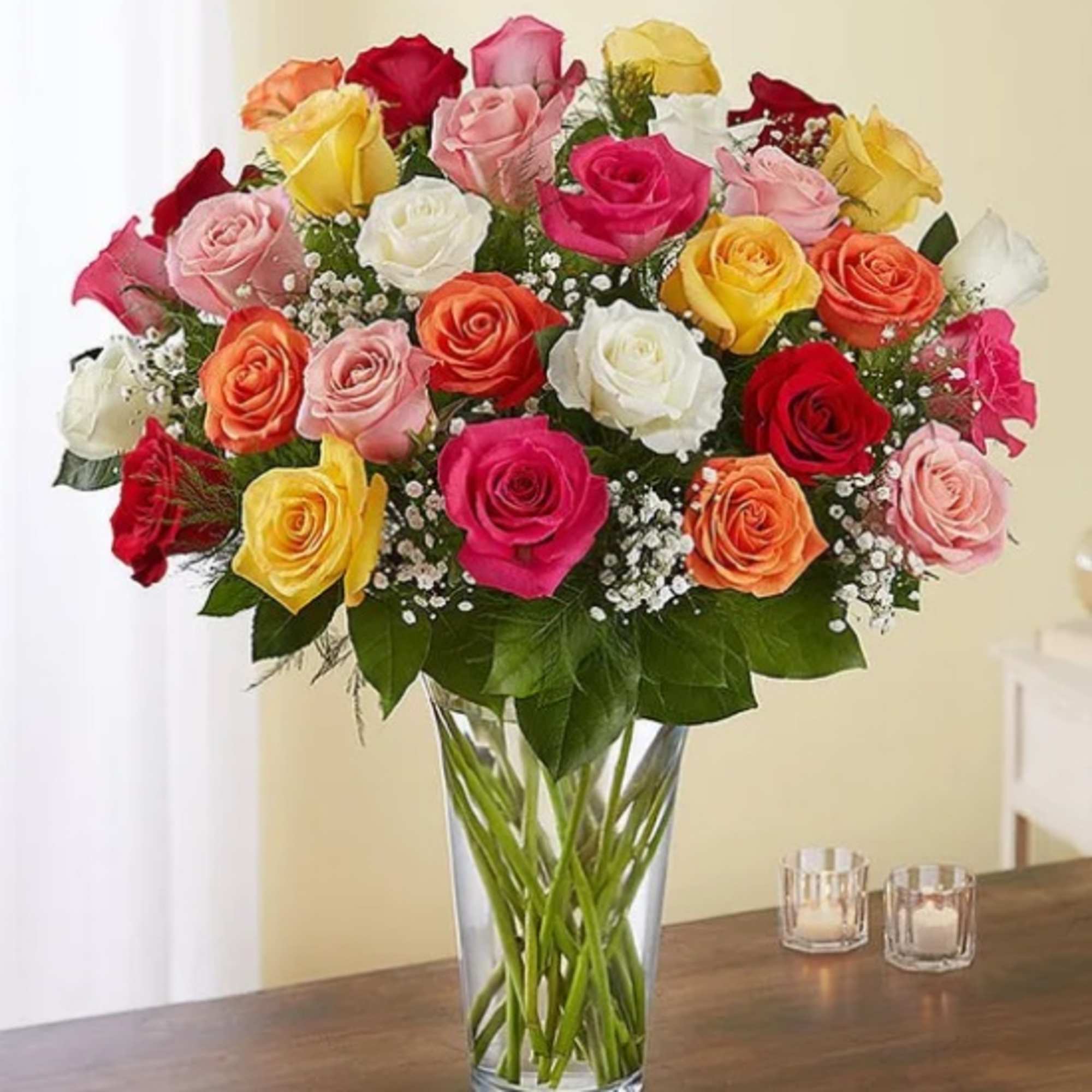 Mixed roses in a clear glass vase with baby's breath