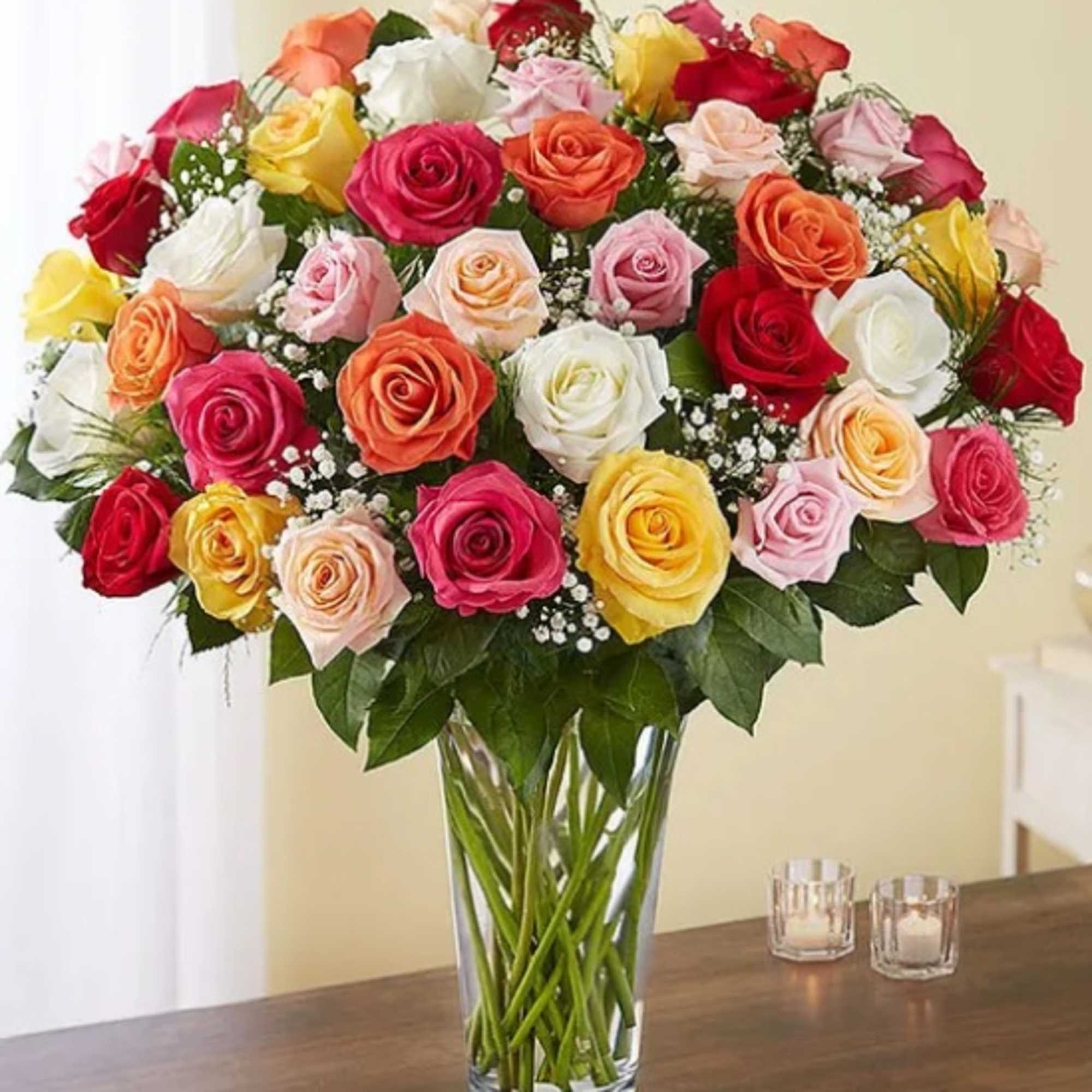Mixed roses in a clear glass vase on a table