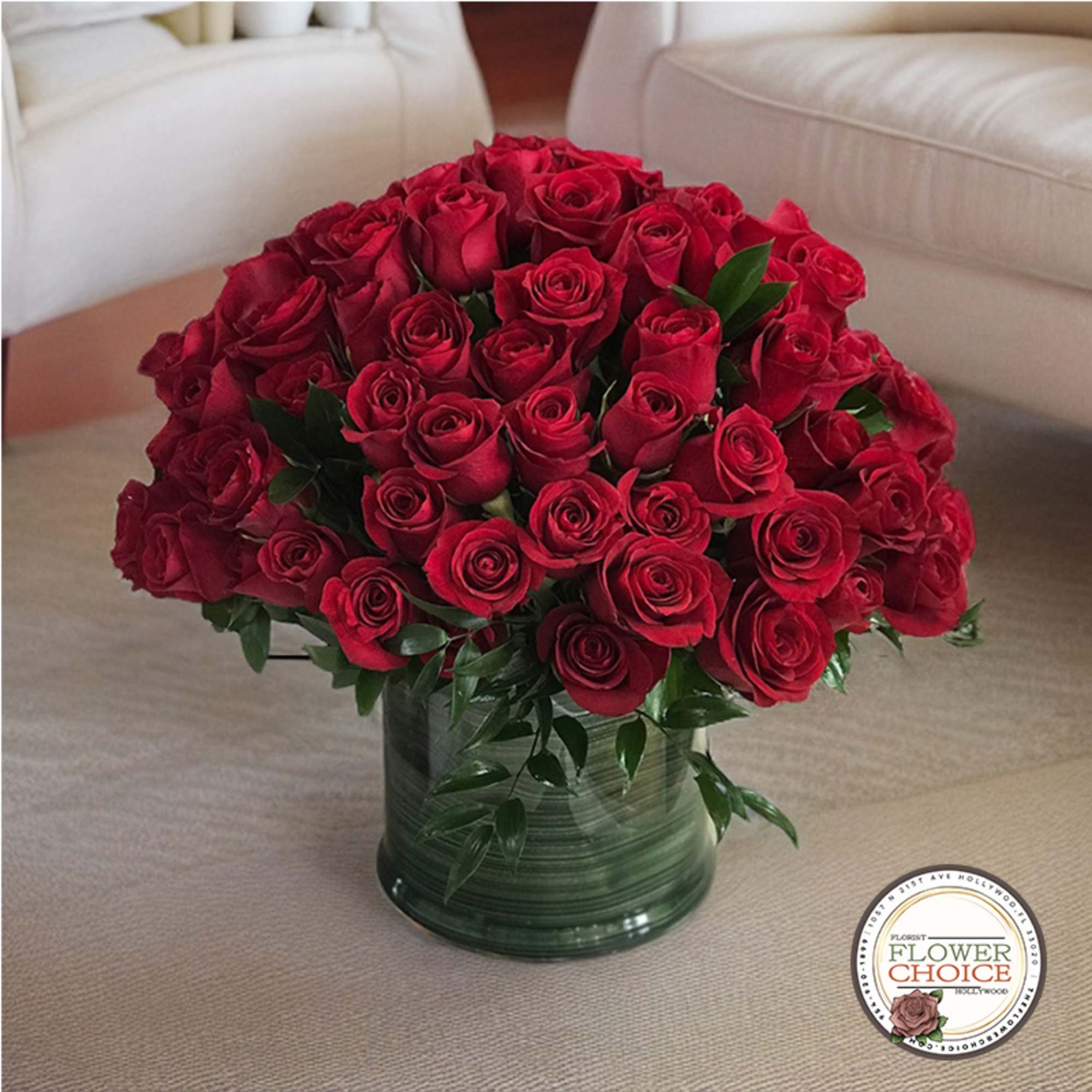 Red roses arranged in a green glass vase