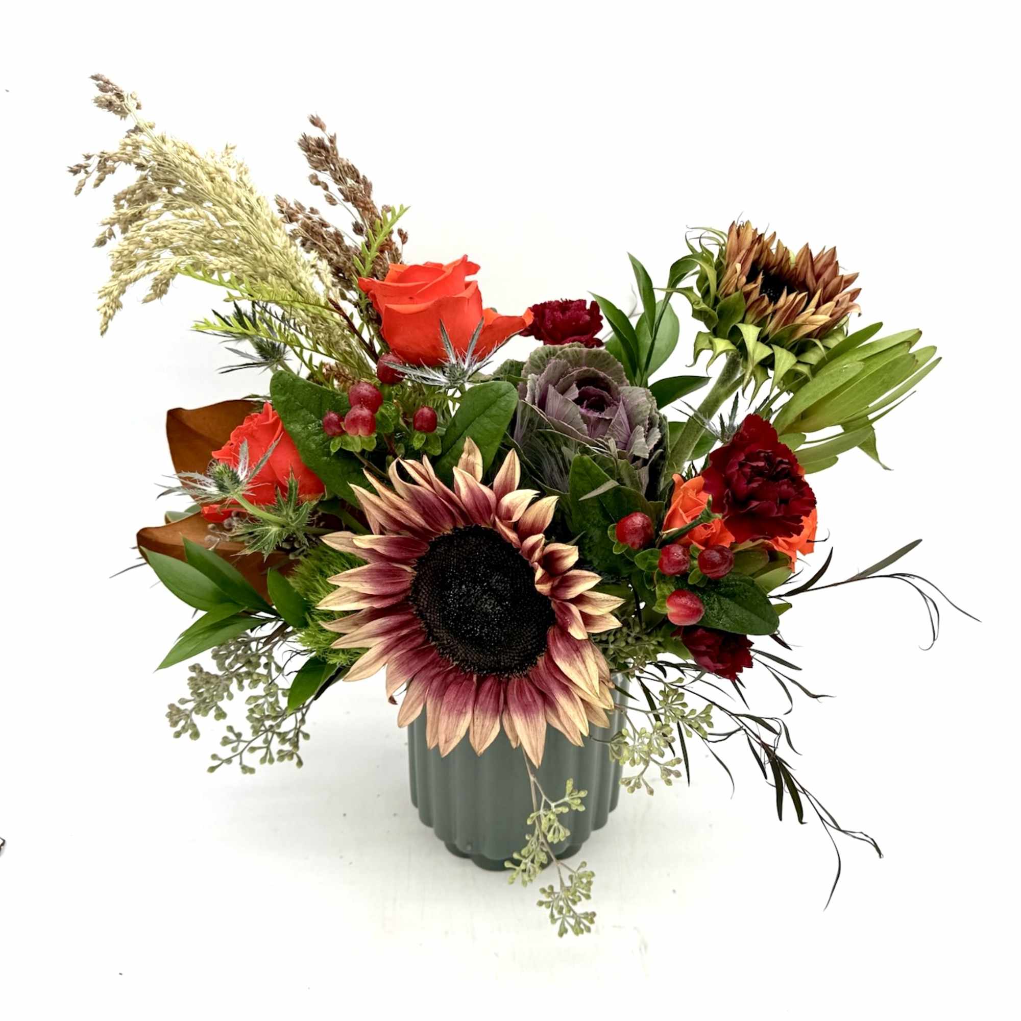 Sunflower and rose arrangement in a green vase