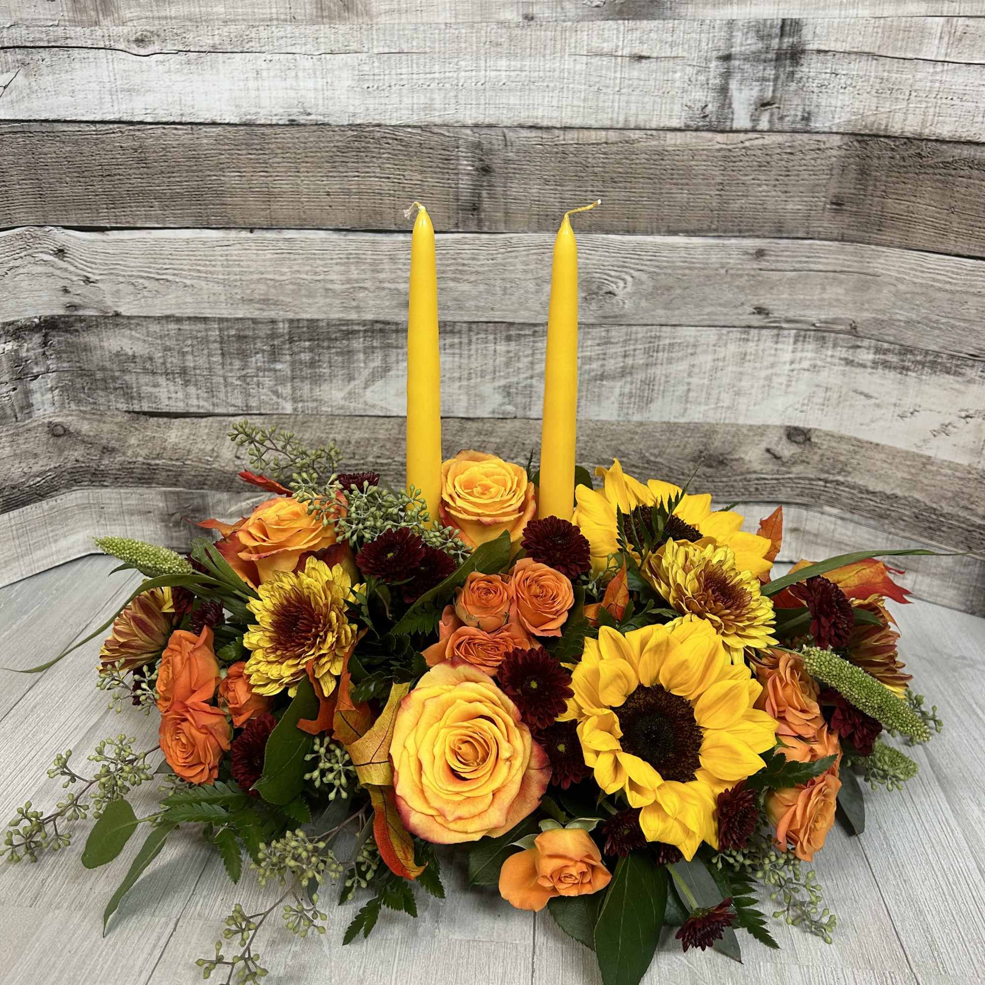 This centerpeice brings a variety of florals like sunflowers, orange spray roses