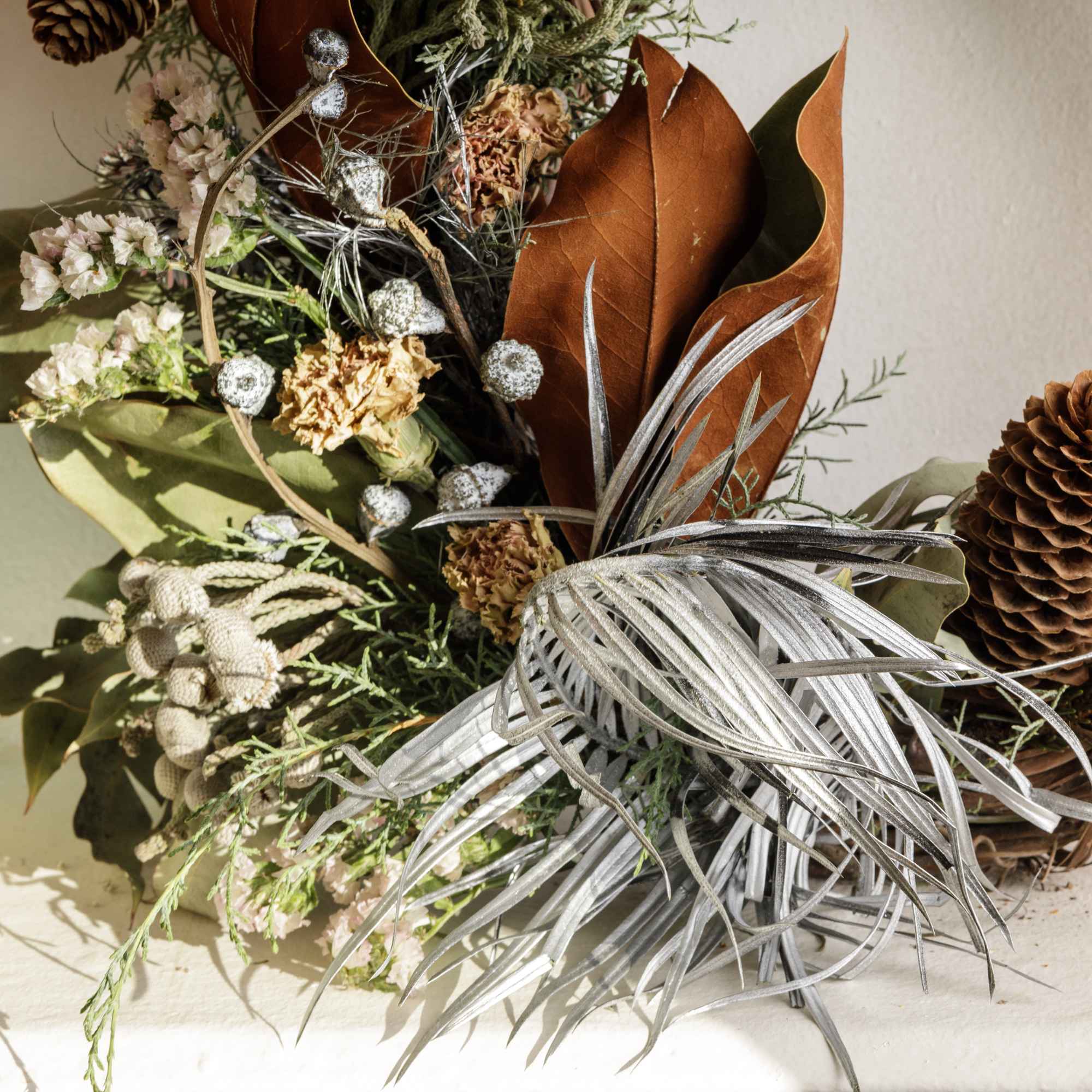 Dried floral arrangement with pinecones and silver foliage